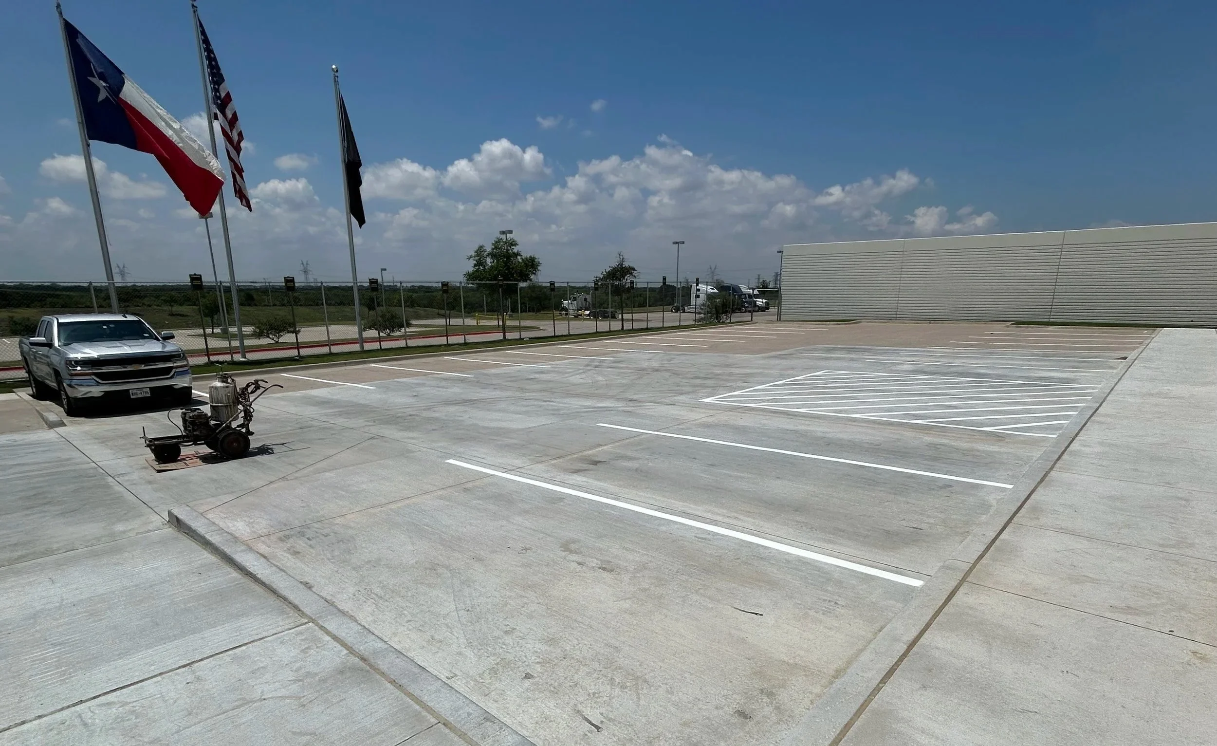 Newly paved parking lot with fresh striping and joint sealant. 