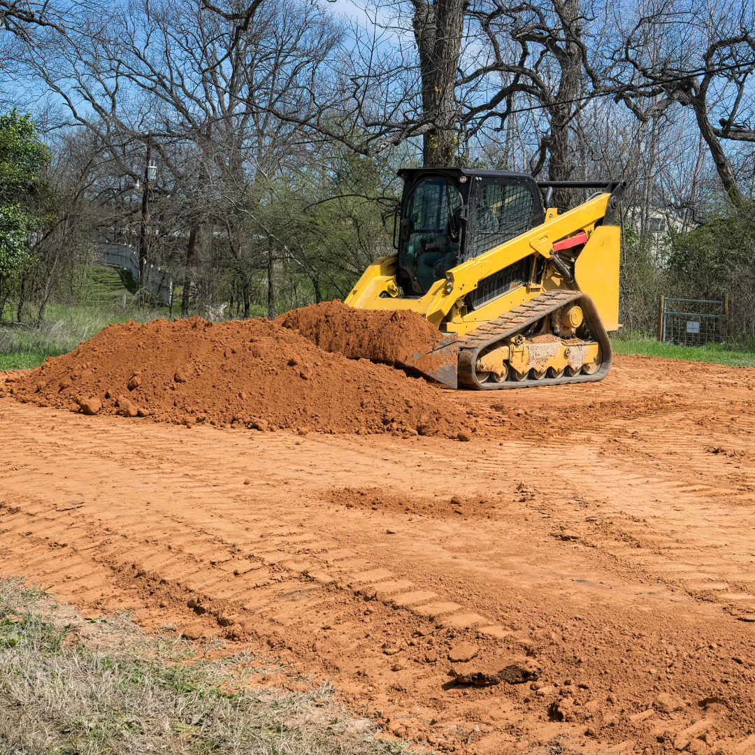 Heavy machinery leveling dirt on a construction site.