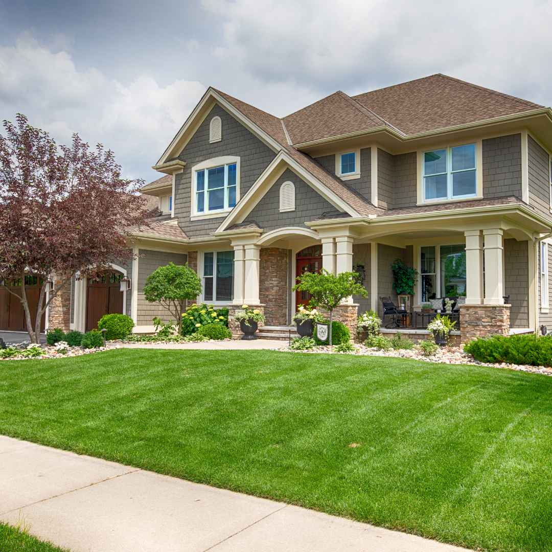Beautiful suburban home with a lush green lawn and landscaped garden.