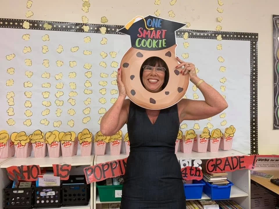 Elementary teacher celebrating student achievement in the classroom.