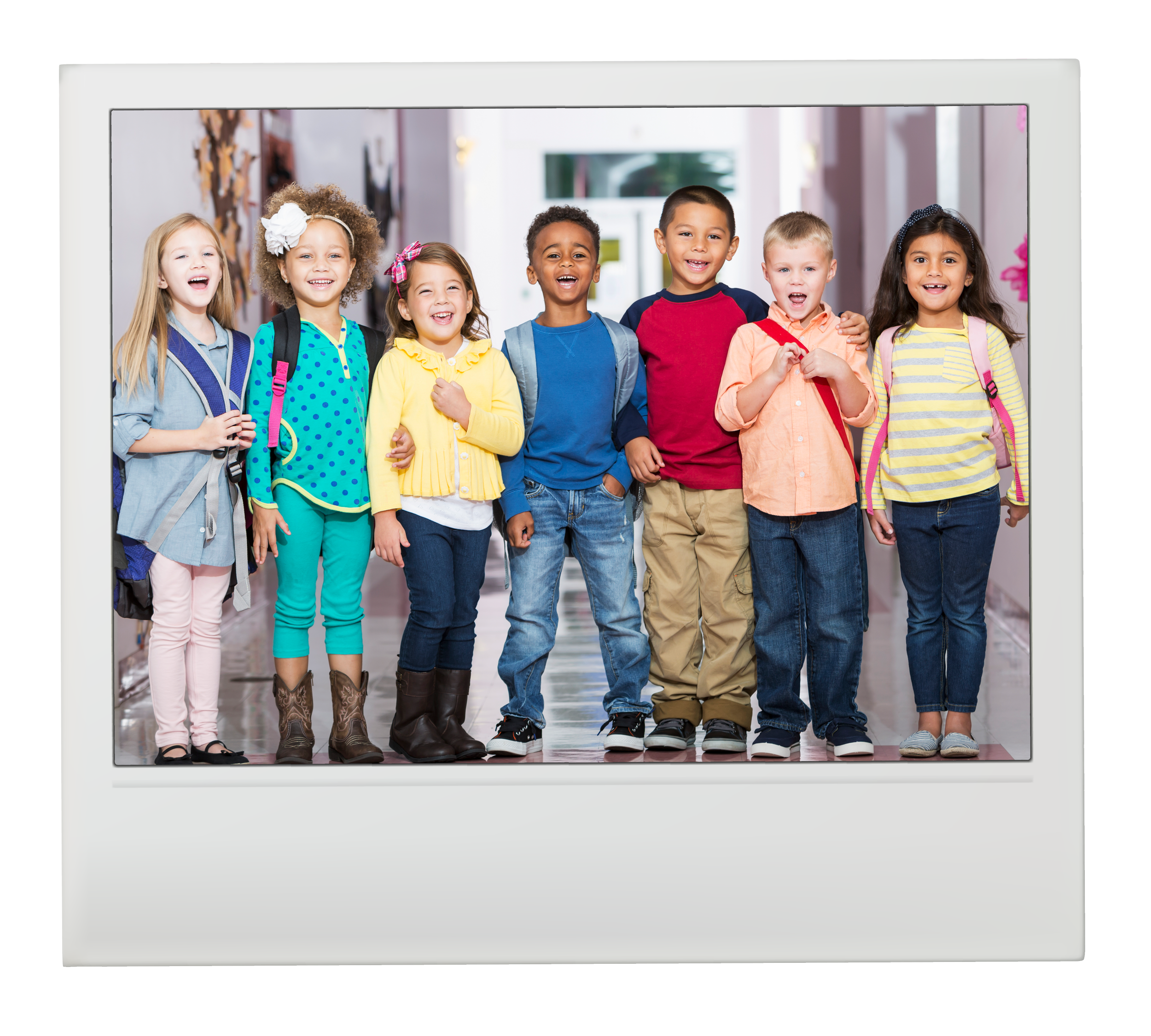 Group of seven children standing in a school hallway, smiling and carrying backpacks.