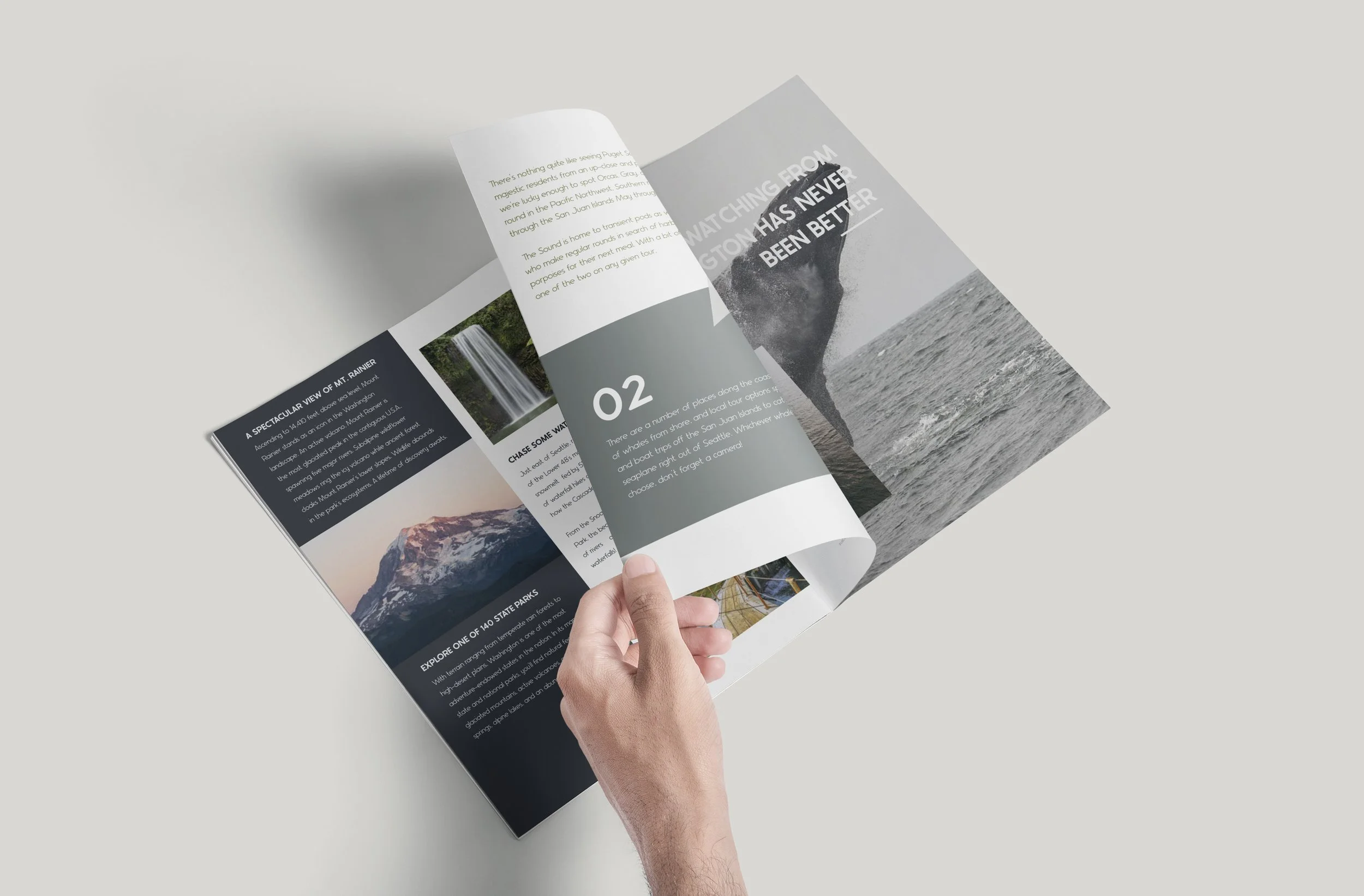 A person flipping through a travel brochure with images of mountains, waterfalls, and ocean views.
