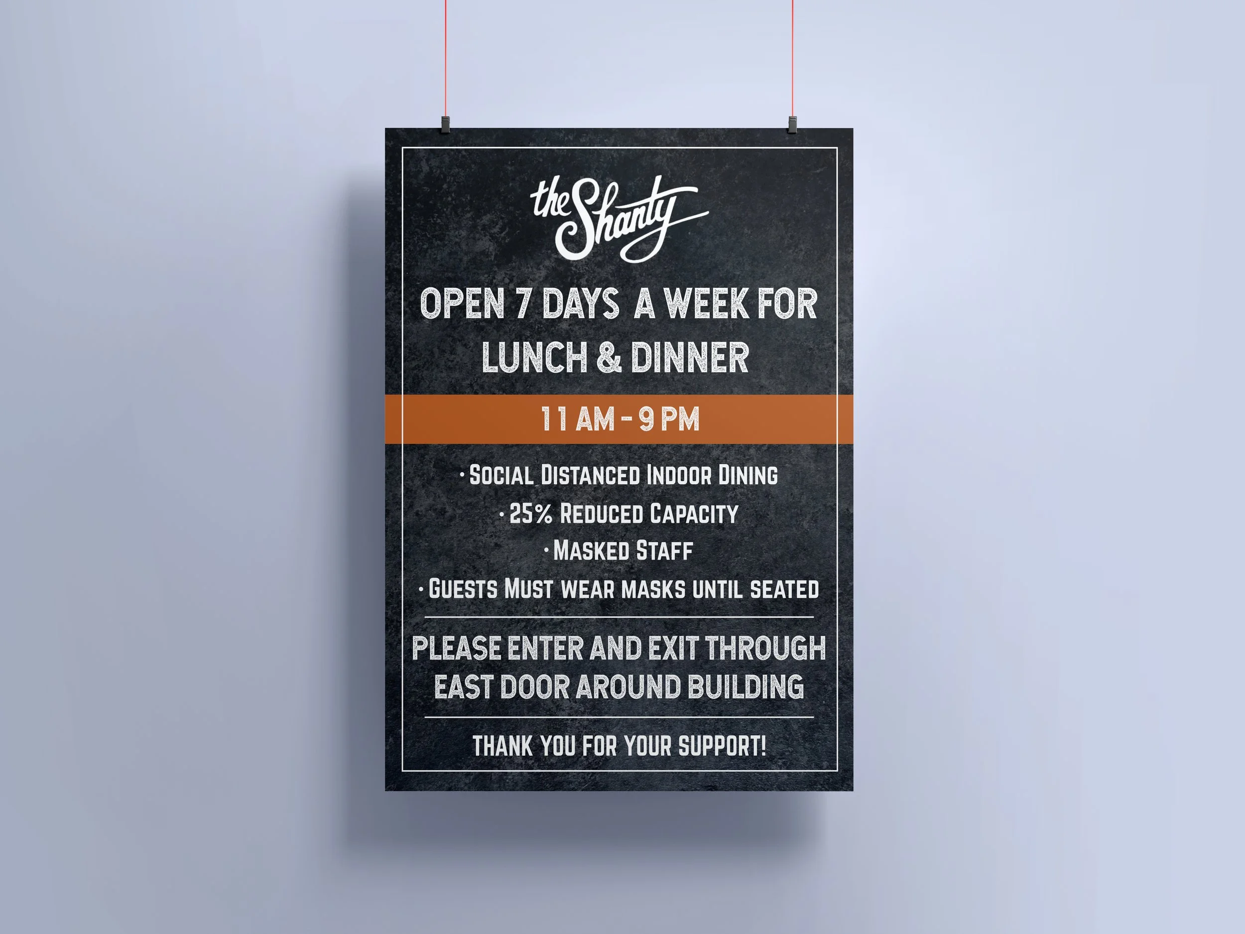 Signboard for The Shanty restaurant, open 7 days a week for lunch and dinner, 11 am to 9 pm, with social distancing, reduced capacity, masked staff, and masked guests, and instructions for entering and exiting the building.