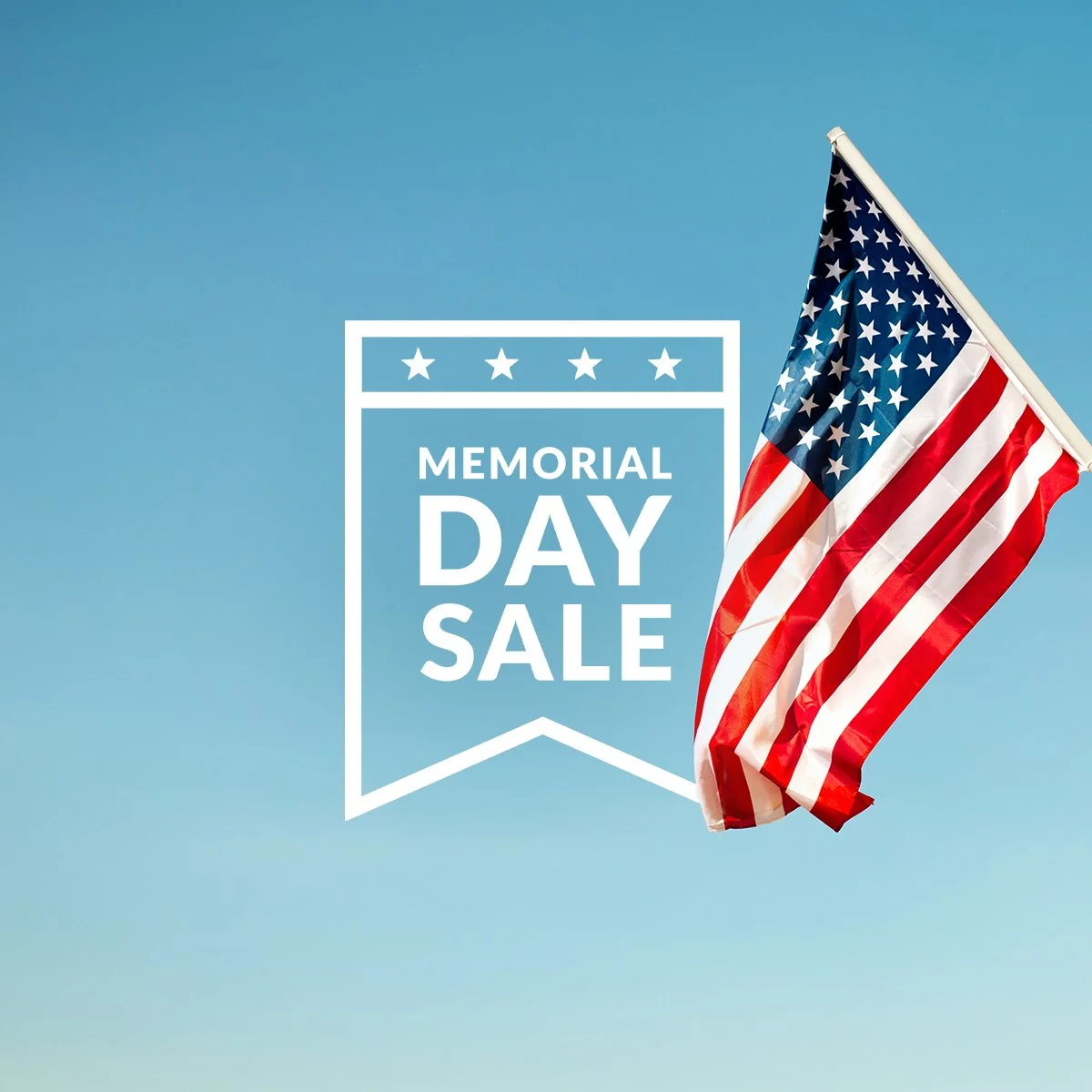 A patriotic American flag waving against a clear blue sky with an overlay text announcing a Memorial Day sale, surrounded by a box with stars at the top.