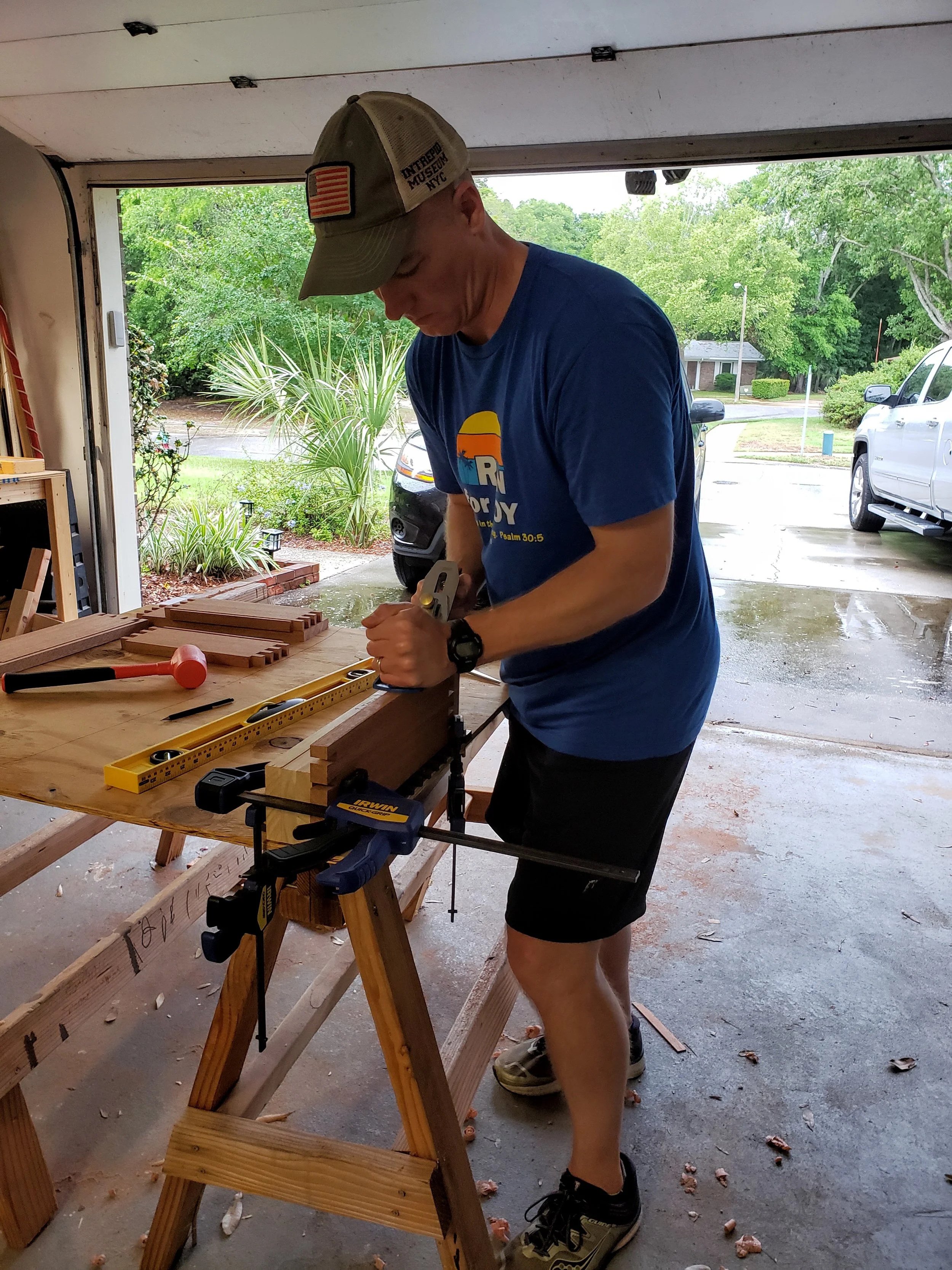 Mike “Hondo” Fiandt working on a custom dovetail African mahogany keepsake box woodworking project. Customized wood work building starts in the garage.