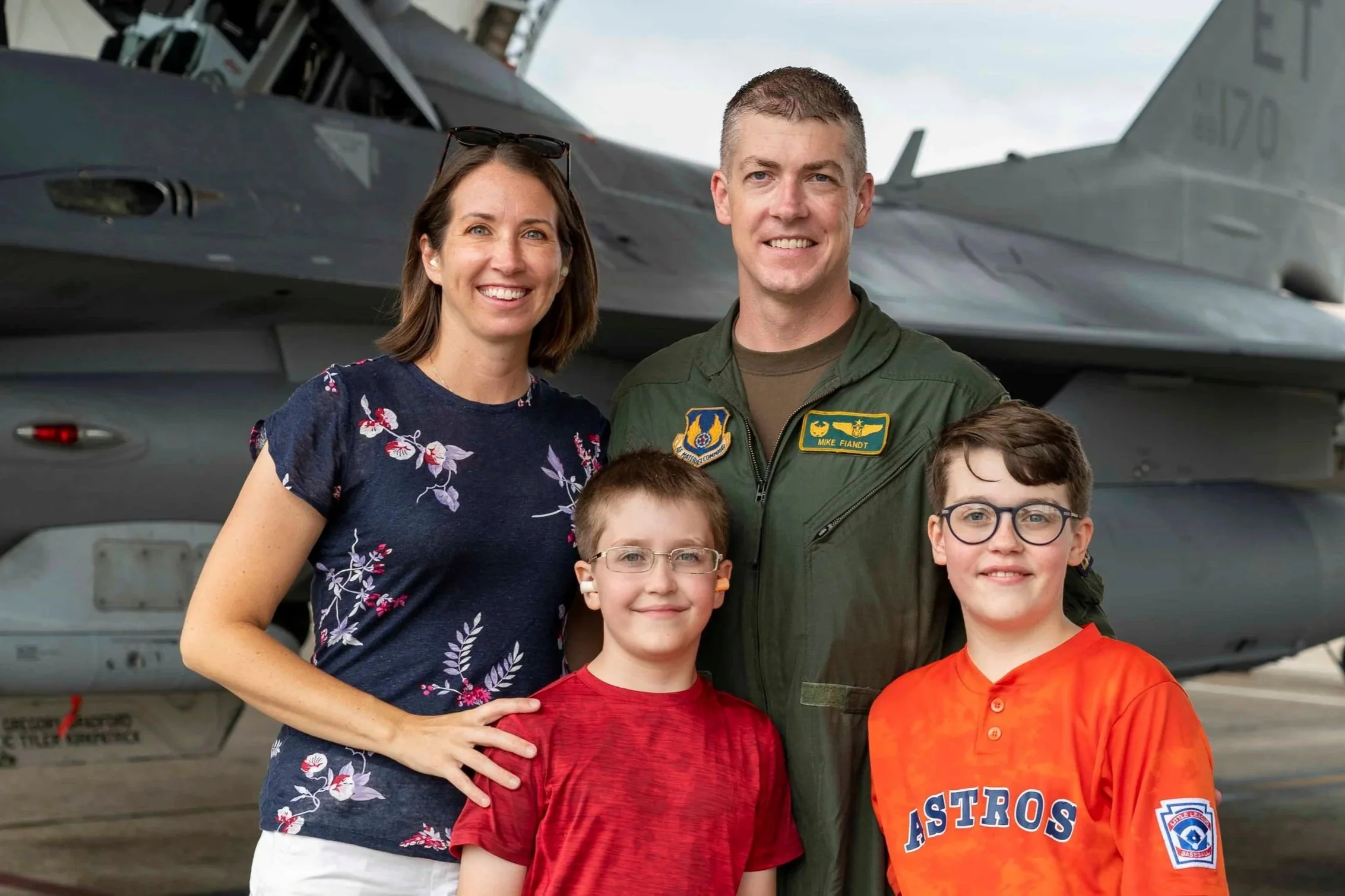 Family of four posing in front of an F-16 fighter jet. This is Mike “Hondo” Fiandt, owner of Hondo’s Wood Co, and his family. Hondo is a proud Air Force veteran, engineer, and wood worker.