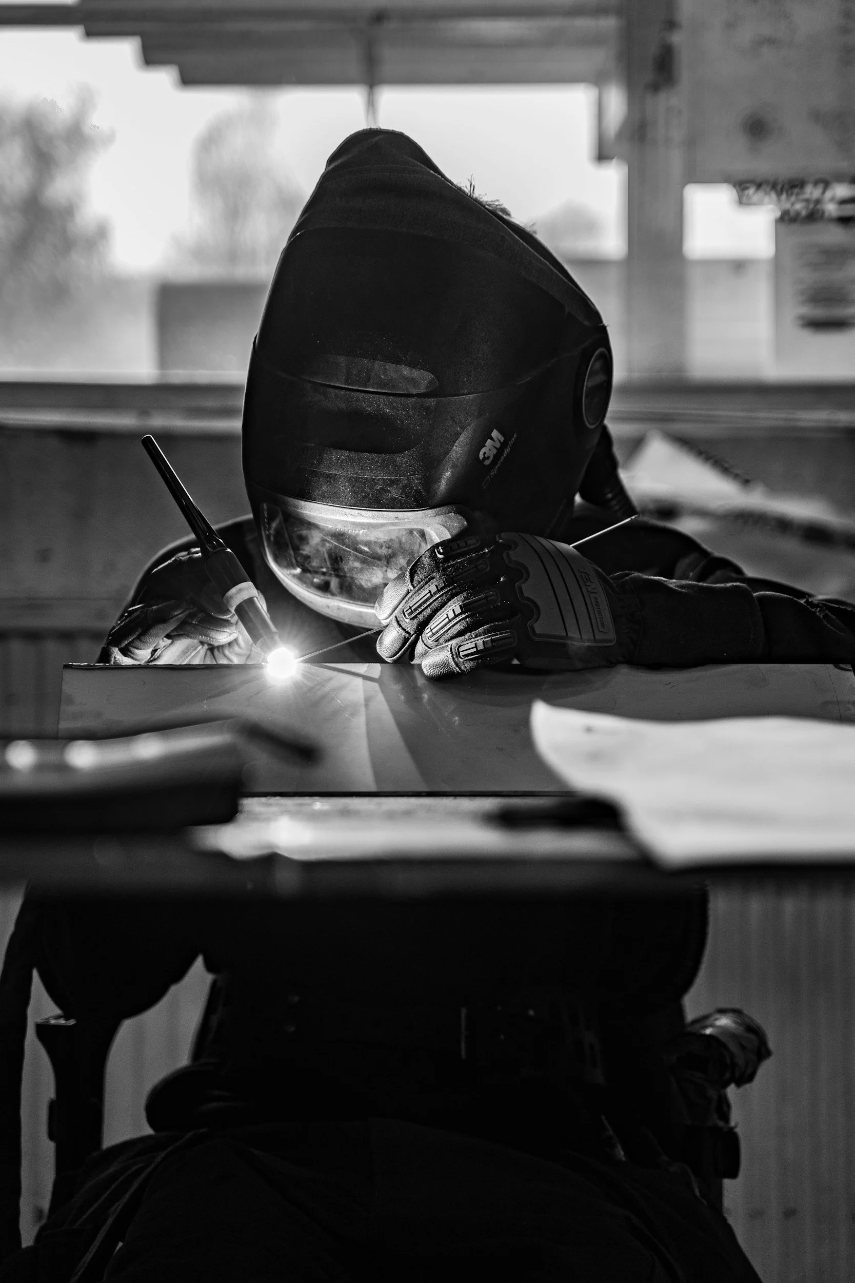 Welder in a protective helmet welding metal