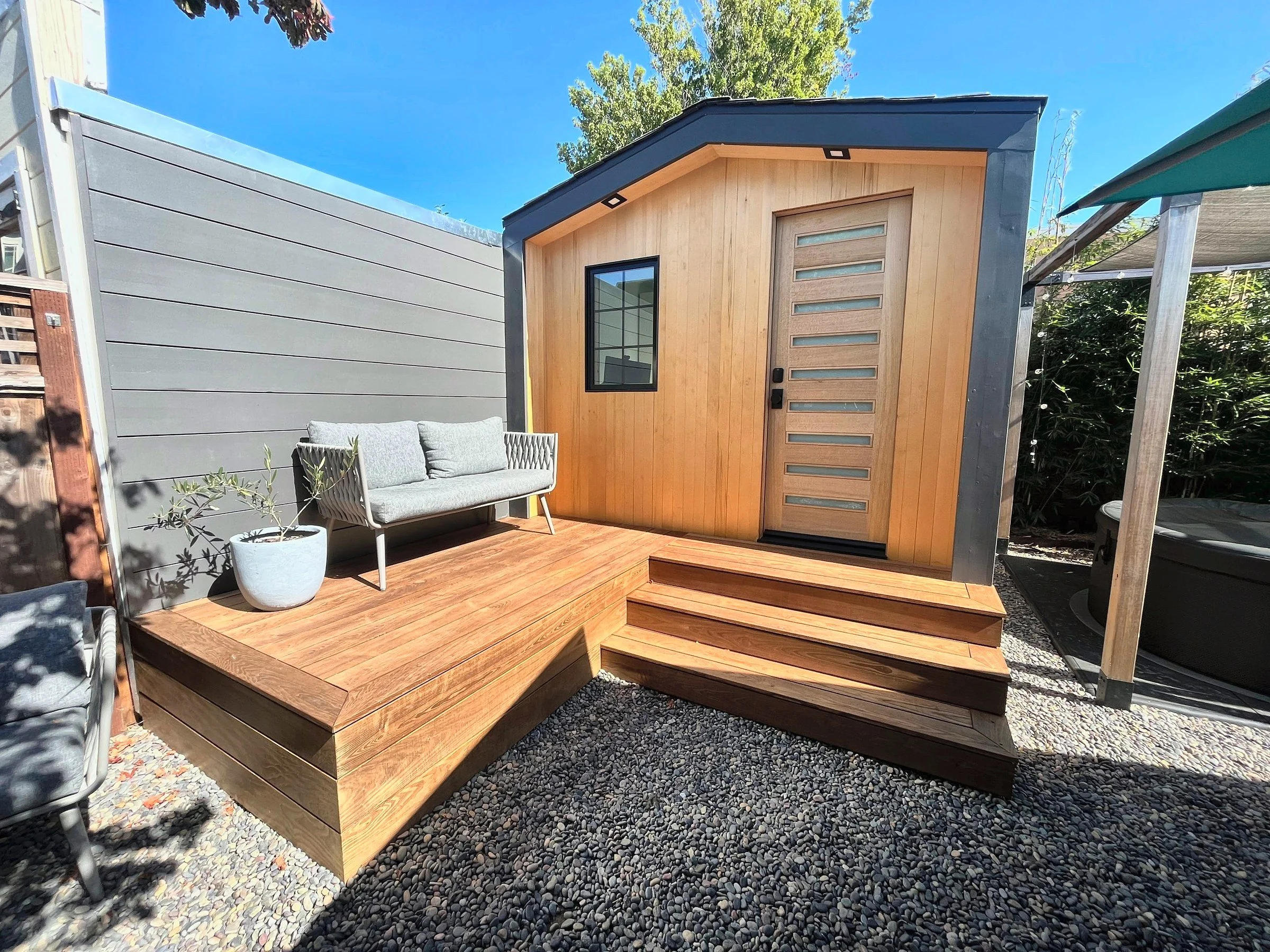 Backyard office cottage with wood siding and deck