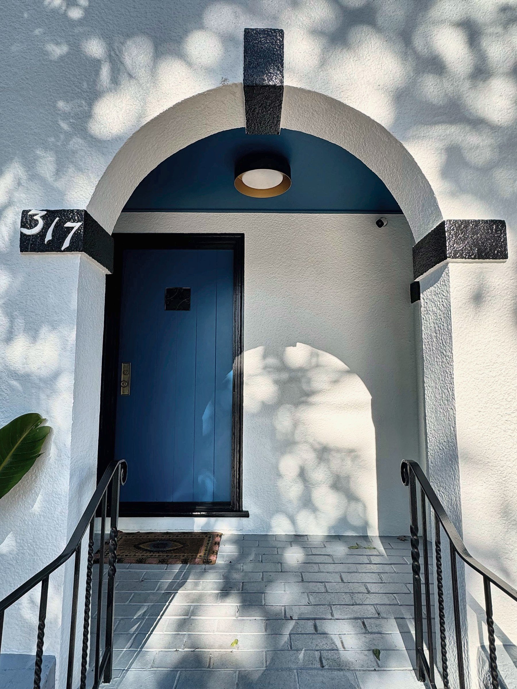 Arched front entry with blue door on a remodeled San Francisco home