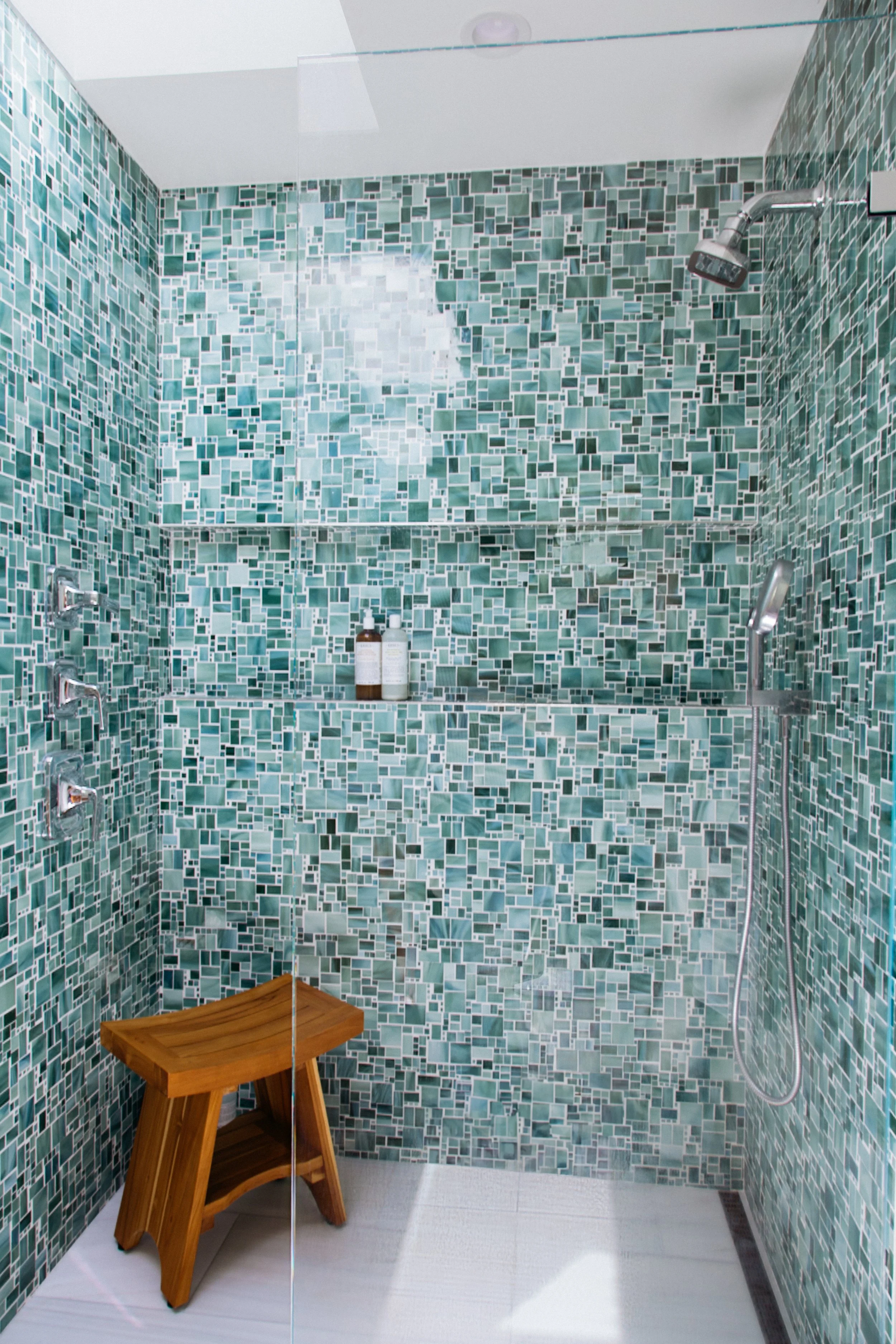 Glass mosaic tile shower with full-width niche and teak bench