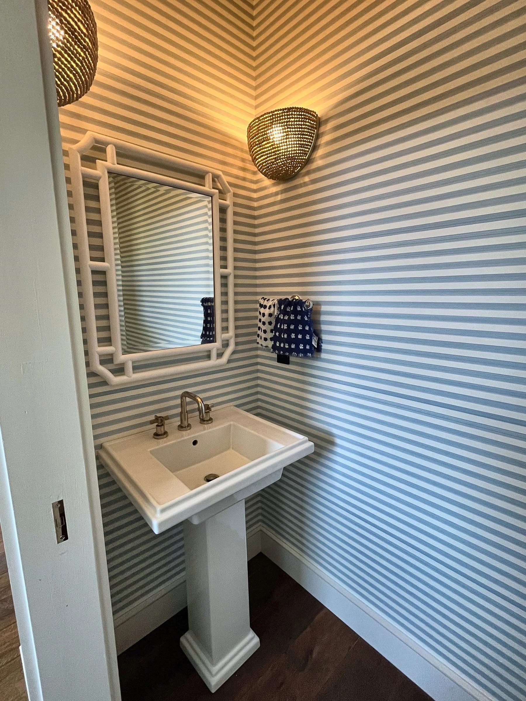 Powder room with pedestal sink, ornate mirror and striped walls