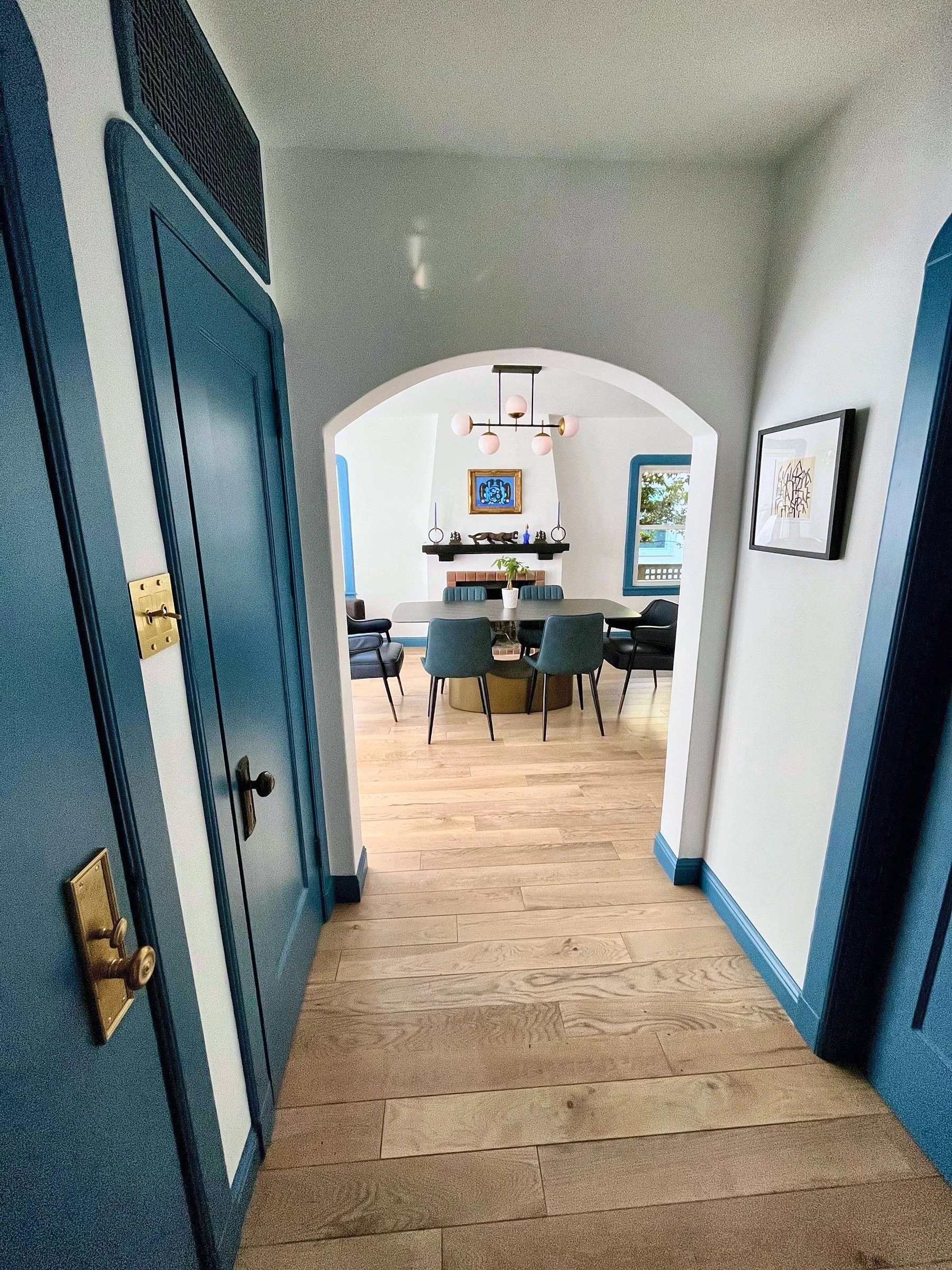 Arched hallway with blue trim leading to the dining room of a 1920s San Francisco bungalow