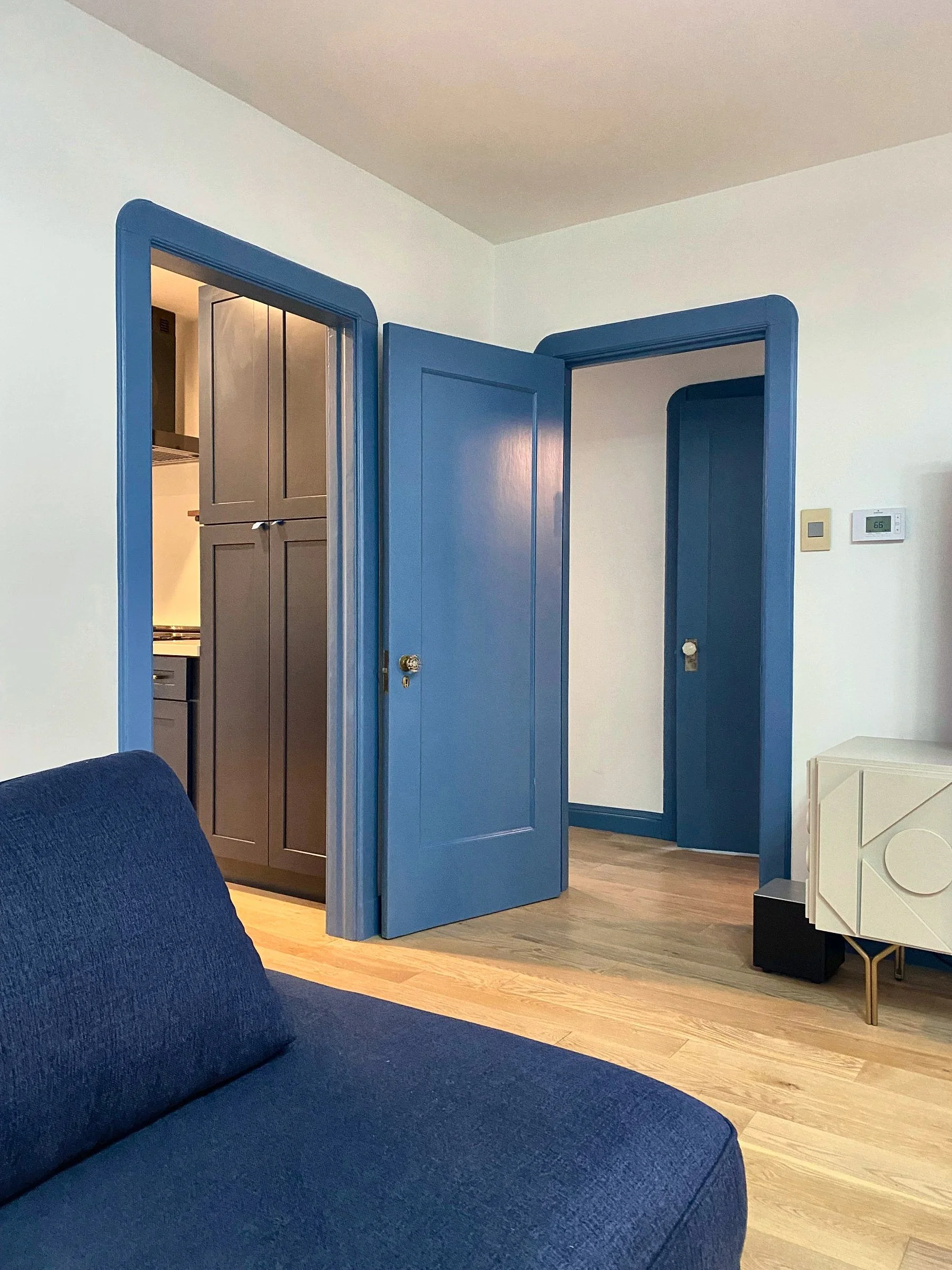 Room with blue-painted doors and trim and light oak floors
