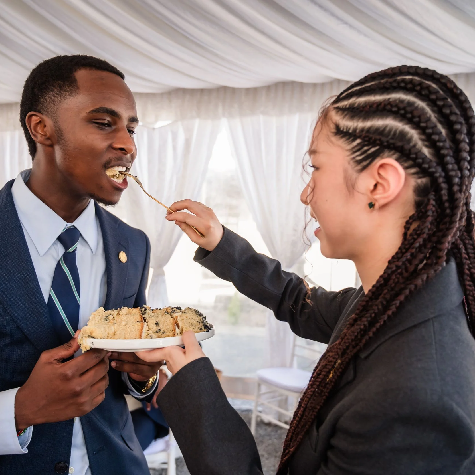 Kenya Youth Leader Representative, Wayne, and South Korea Youth Leader Representative,  Seojin "Summer" Choi, partaking in sharing a celebratory cake