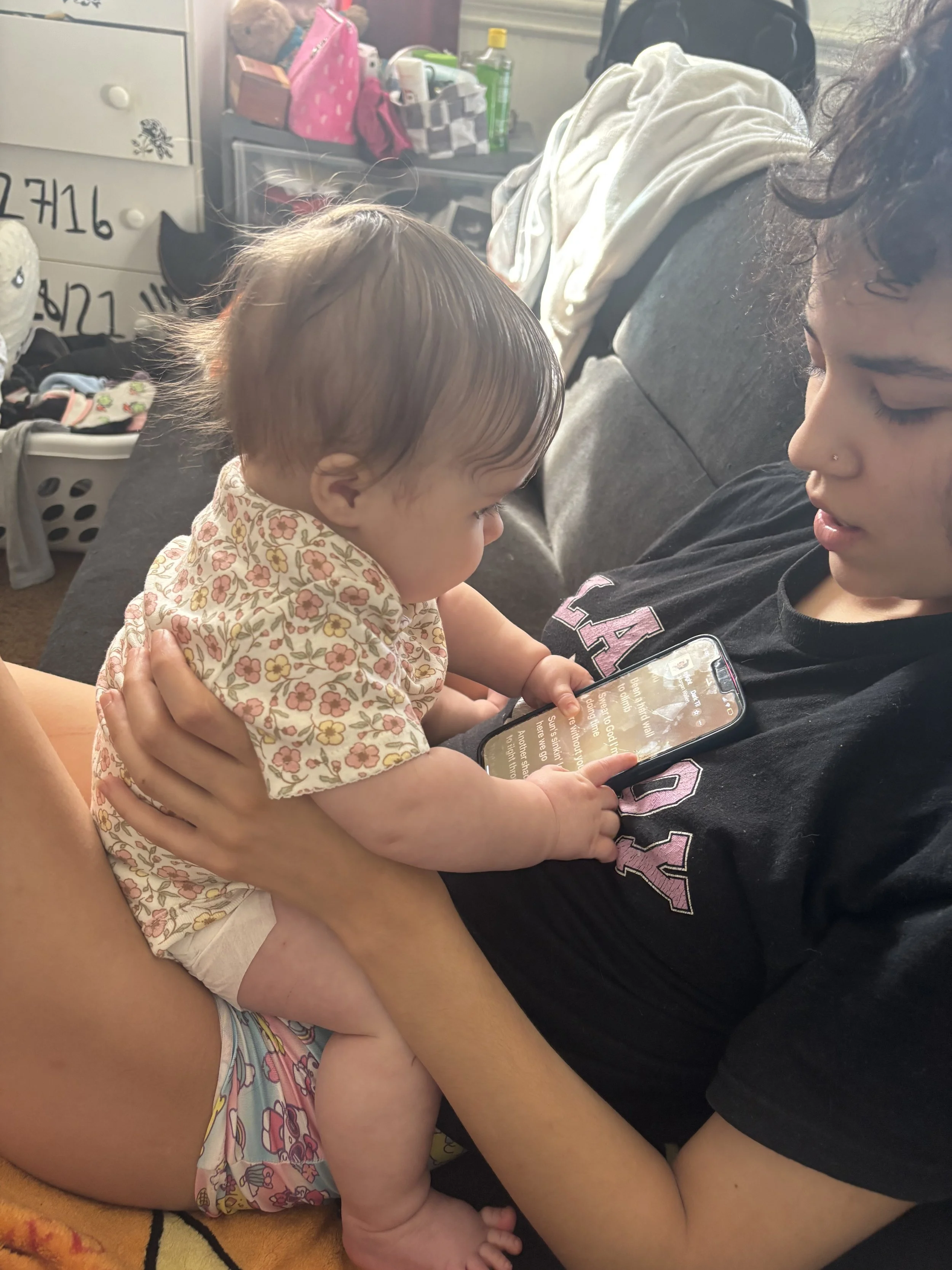 Makayla holding her niece listening to music.