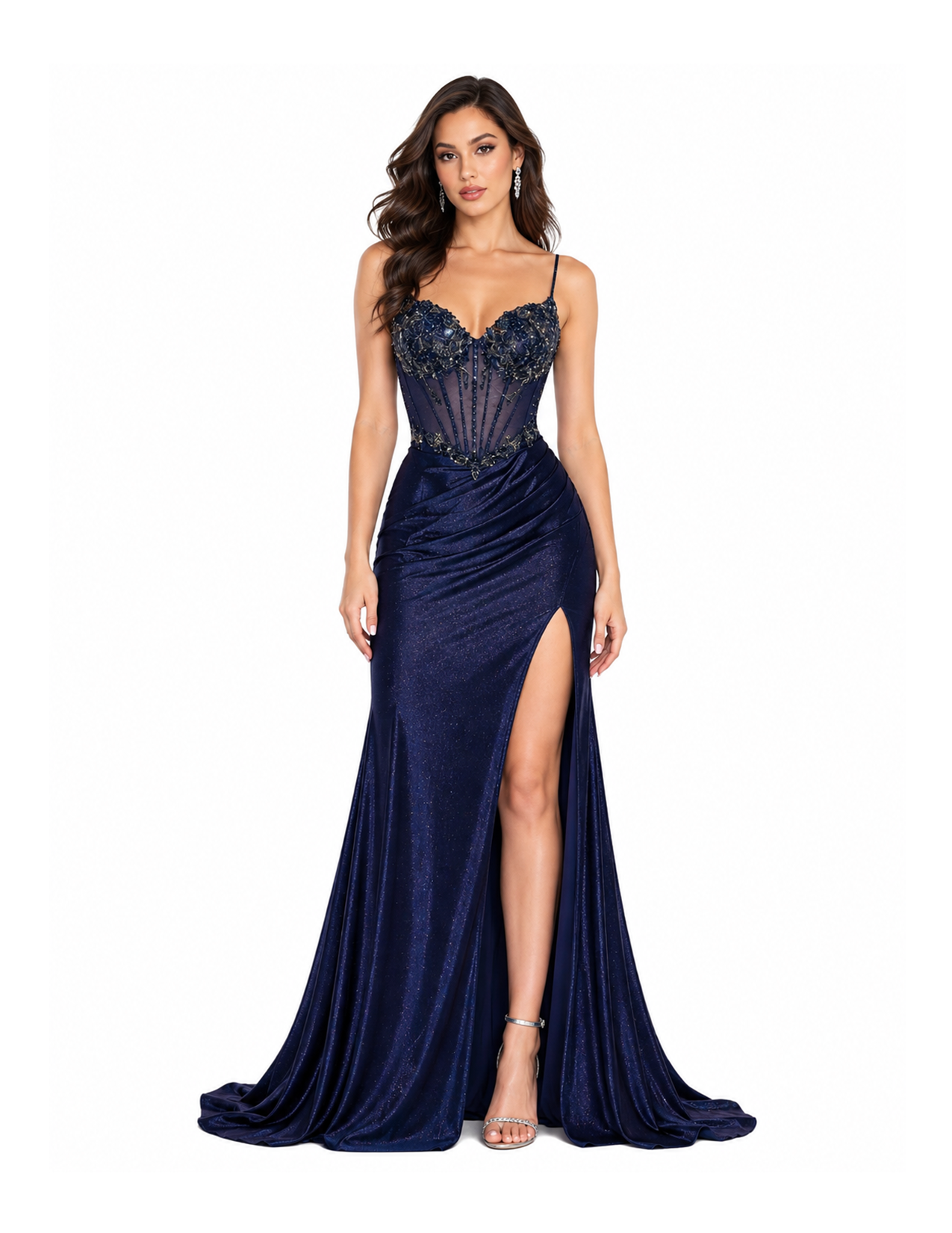 A woman with long dark hair in a blue evening gown with a high slit and embellished bodice, standing against a white background.