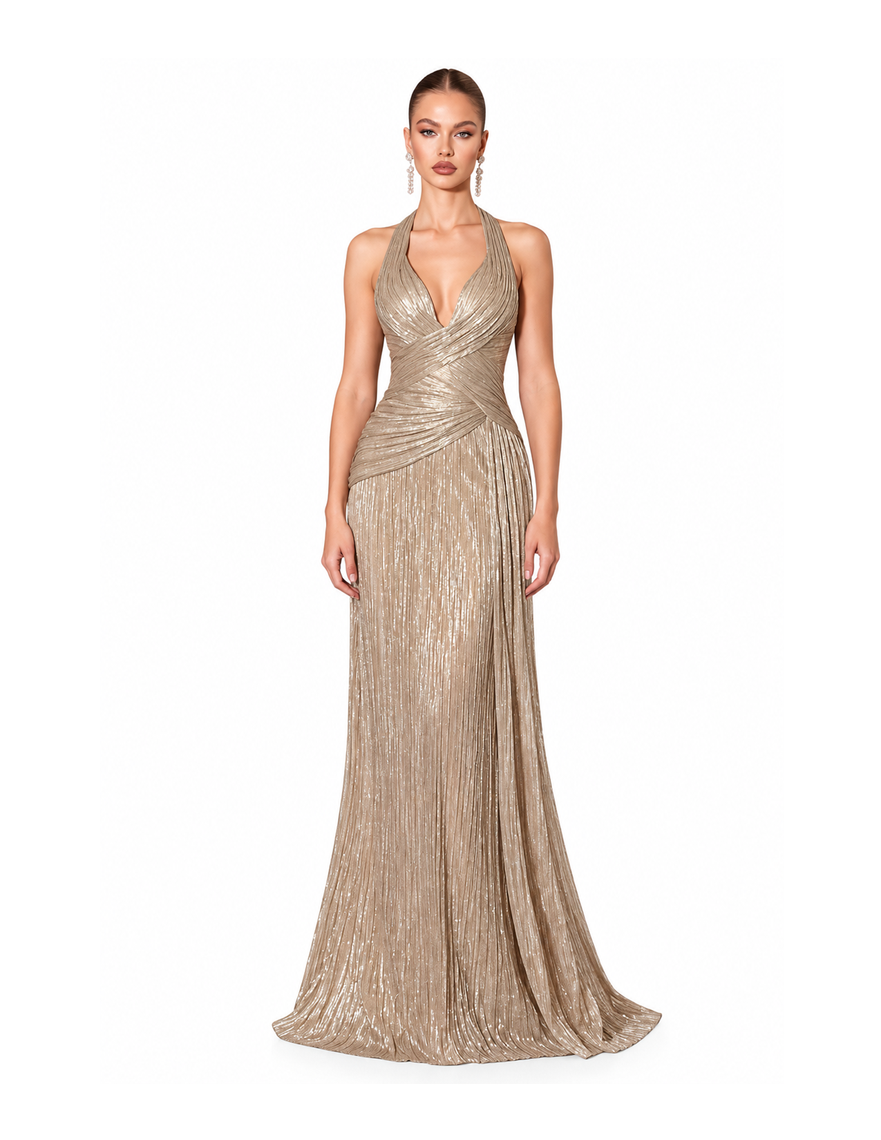 A woman wearing a sleeveless, gold, metallic evening gown with a deep V neckline and pleated design, standing against a plain white background.