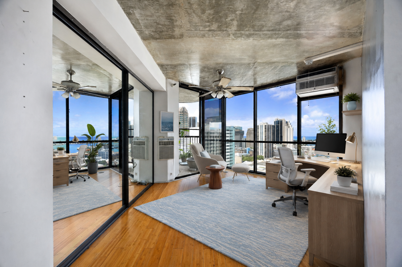 Modern high-rise apartment with panoramic city and ocean views, open workspace with desk, computer, and seating, indoor plants, ceiling fans, large windows, hardwood floors, and minimal decor.