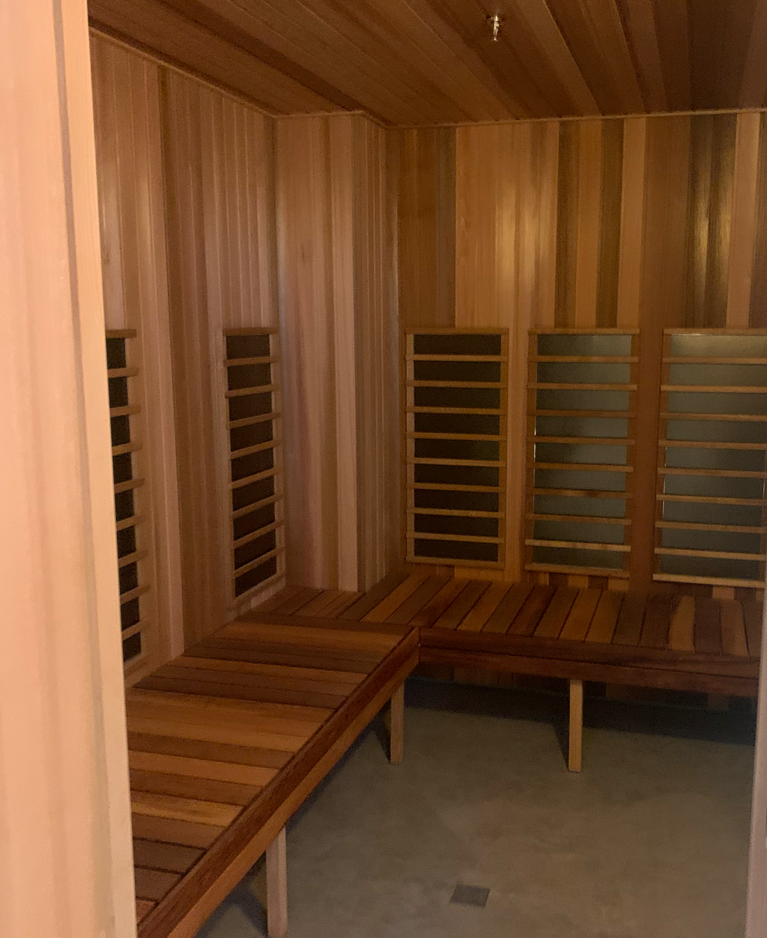 Wood-paneled interior room with benches and slatted walls, a sauna.