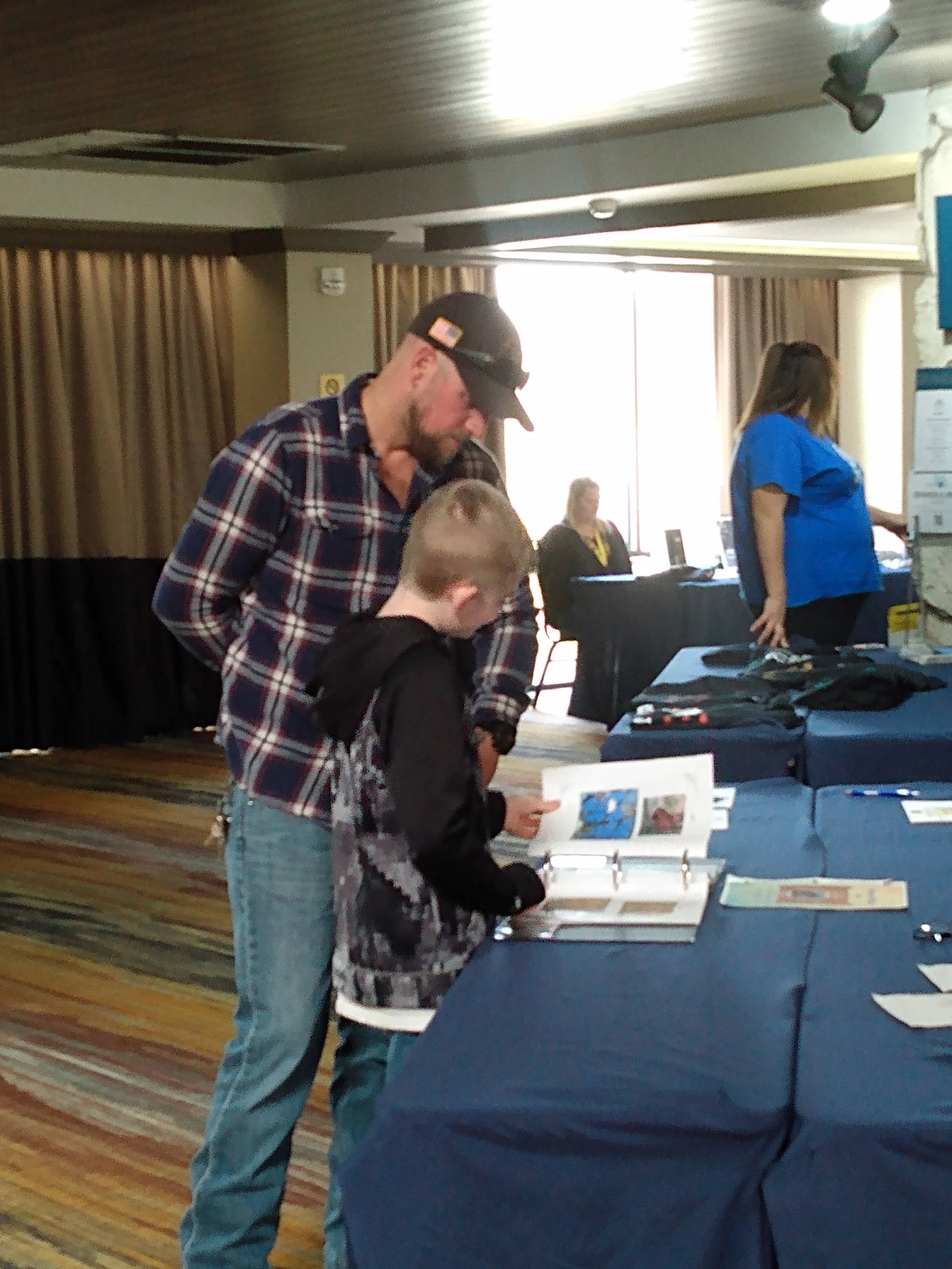People examining displays at an indoor event or conference.