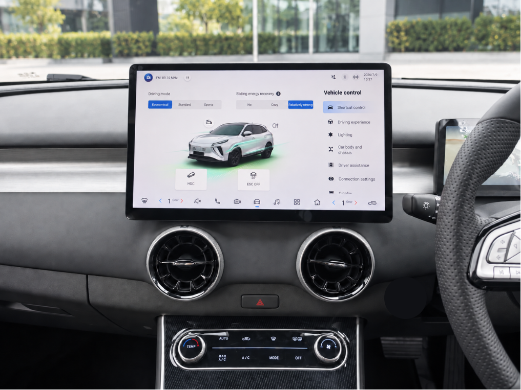 Car dashboard with a digital display showing vehicle controls and a steering wheel on the right side.