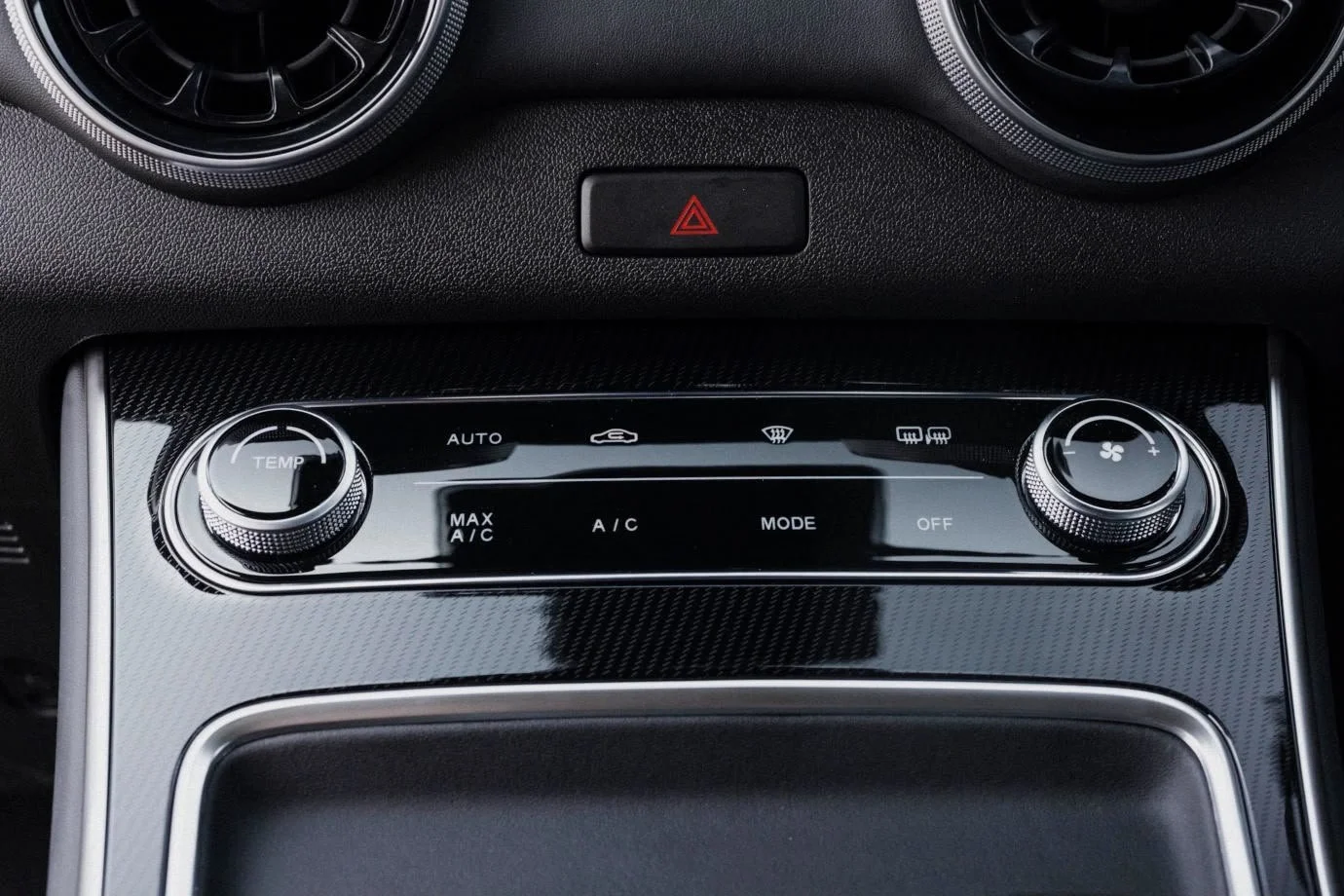 Car climate control panel with buttons for temperature, fan speed, defrost, and airflow mode, located in the center console.