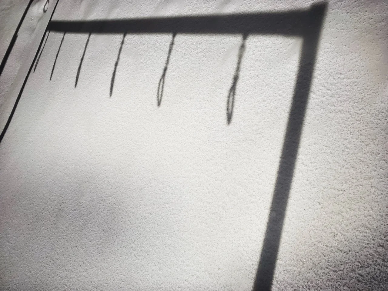 Shadow of a metal rack cast on snow.