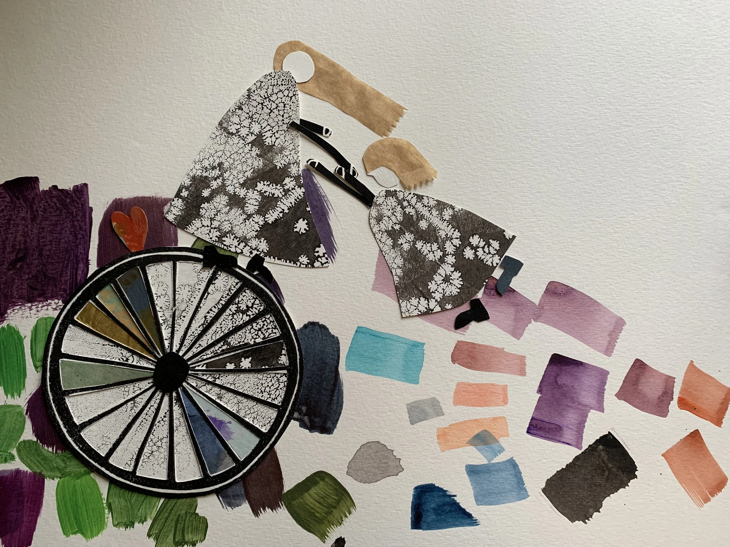 Color wheel with painted swatches and cutouts of black-and-white patterned paper, along with various fabric and paper scraps in different colors and textures.