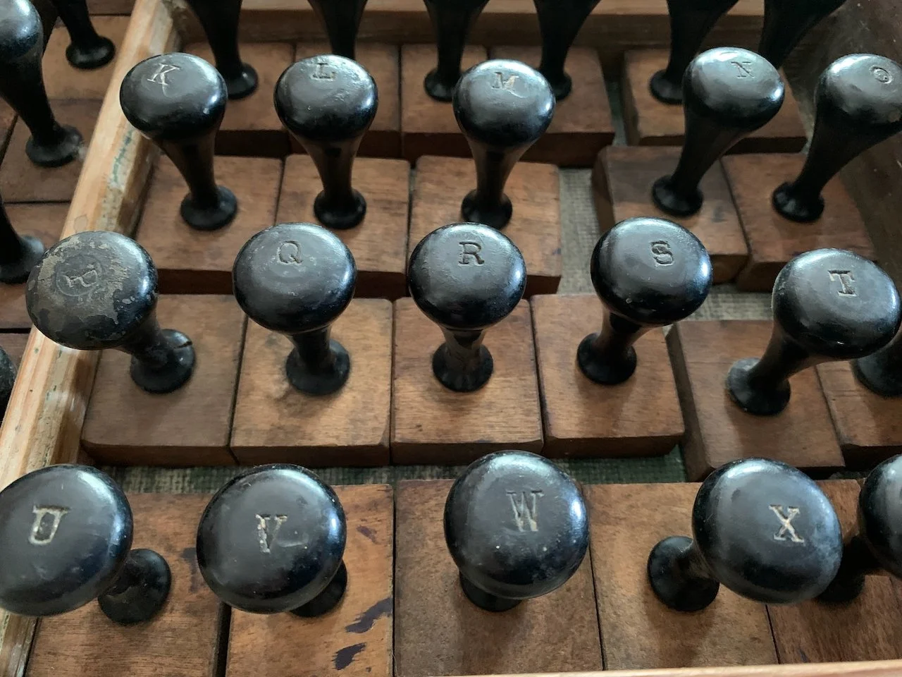 Close-up view of vintage black stamp handles with letter engravings.