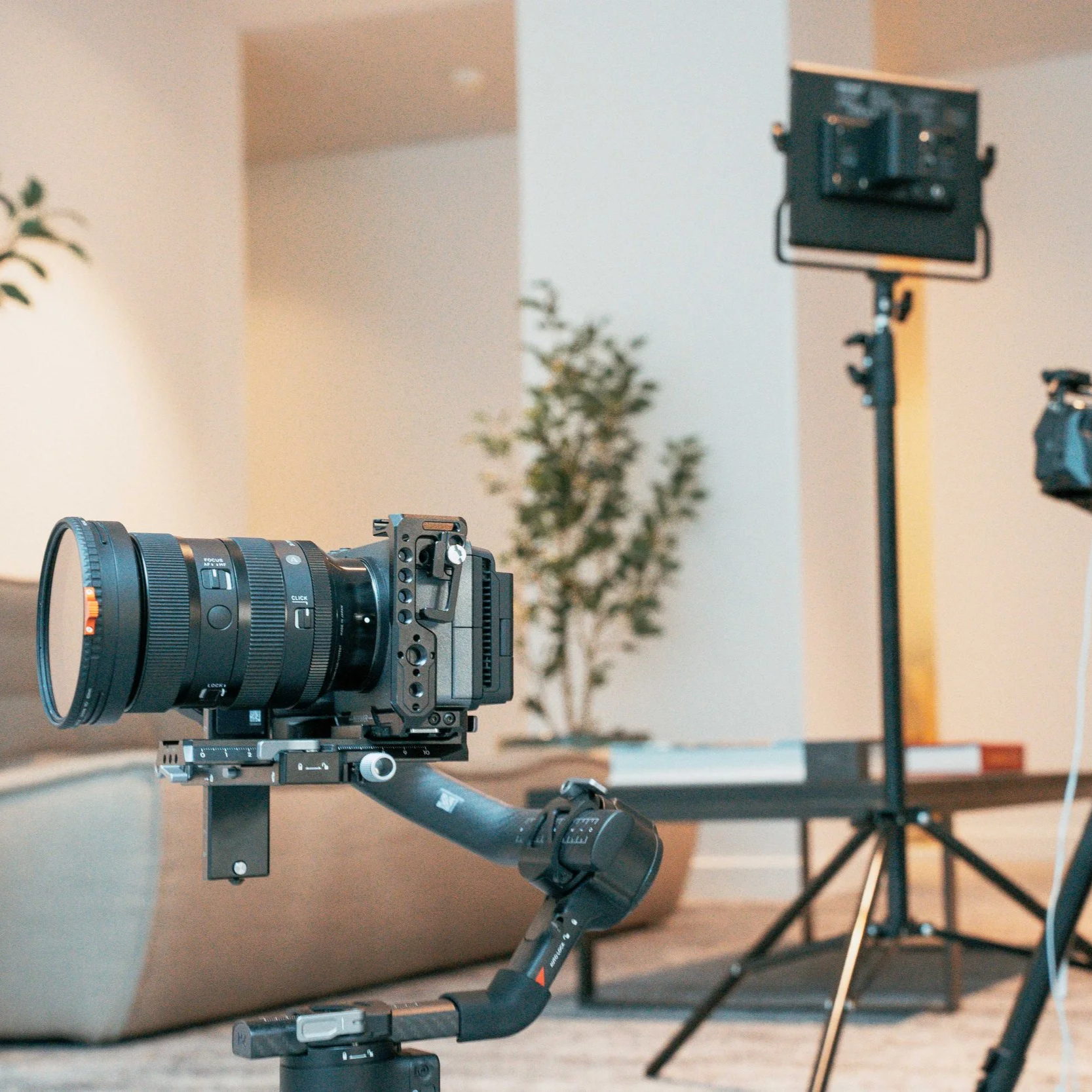 Un caméra montée sur un stabilisateur, avec un éclairage professionnel en arrière-plan, dans un environnement de tournage ou de prise de vue.