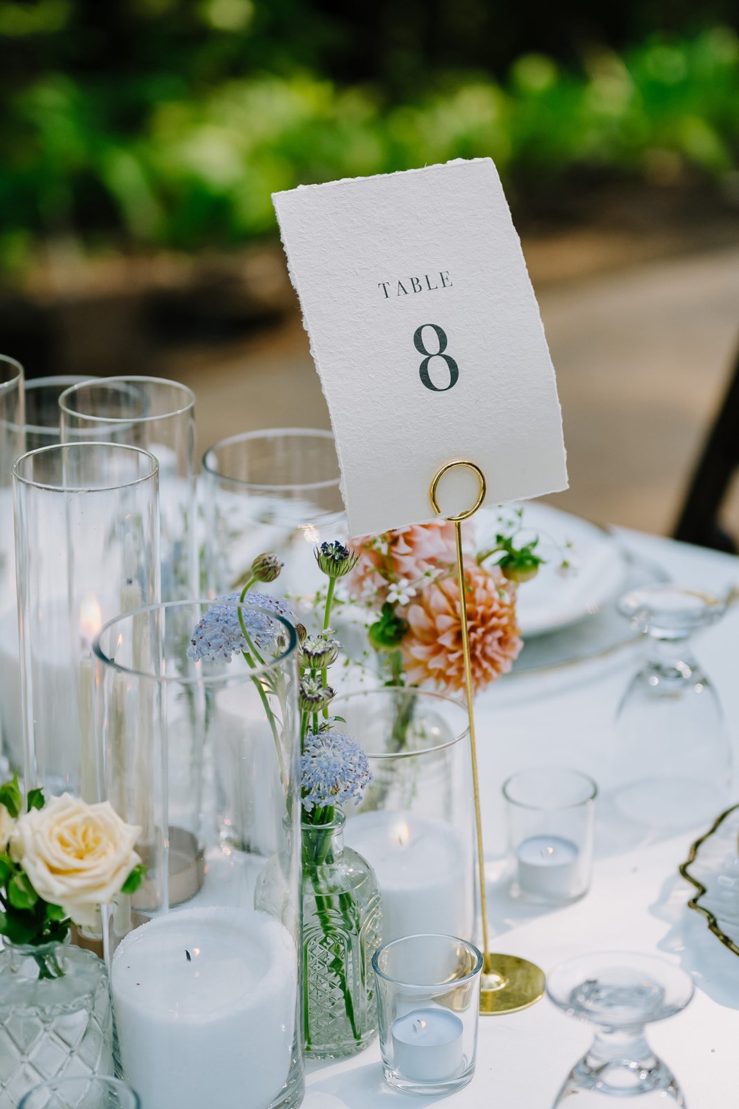 Table setting with floral centerpiece, candles, and a white card with the number 8 indicating table number