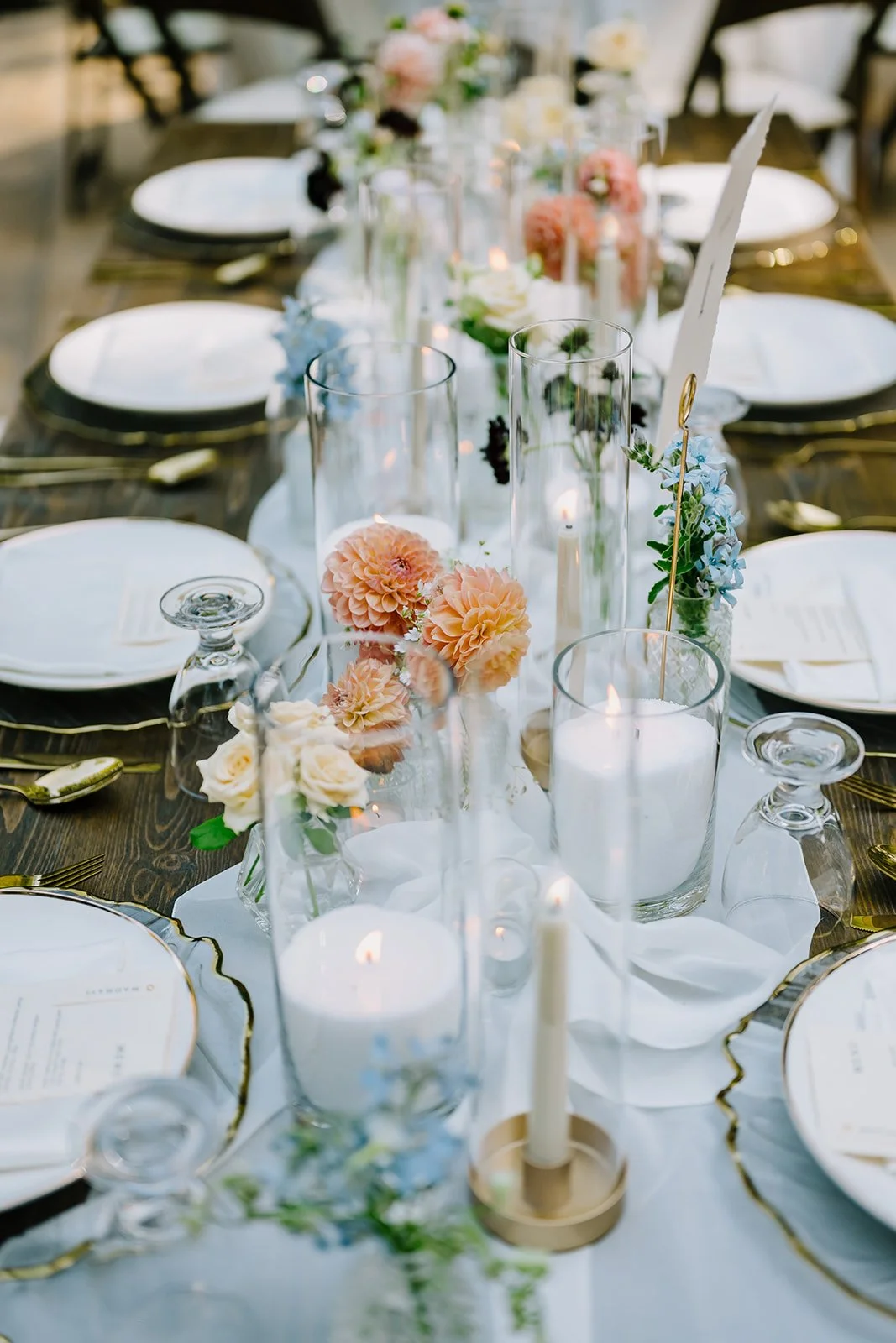 Decorated dining table with floral arrangements and candles at a wedding or event.