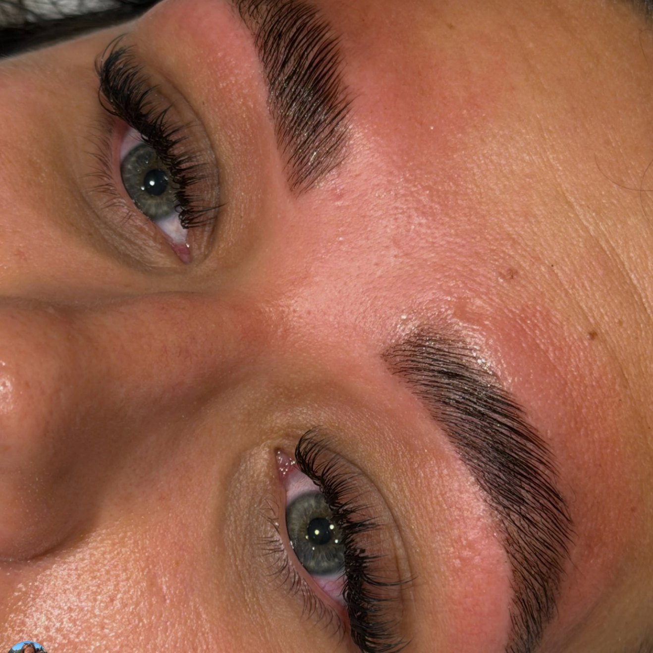 Close-up image of a person's face showing green eyes, well-groomed eyebrows, and smooth skin.