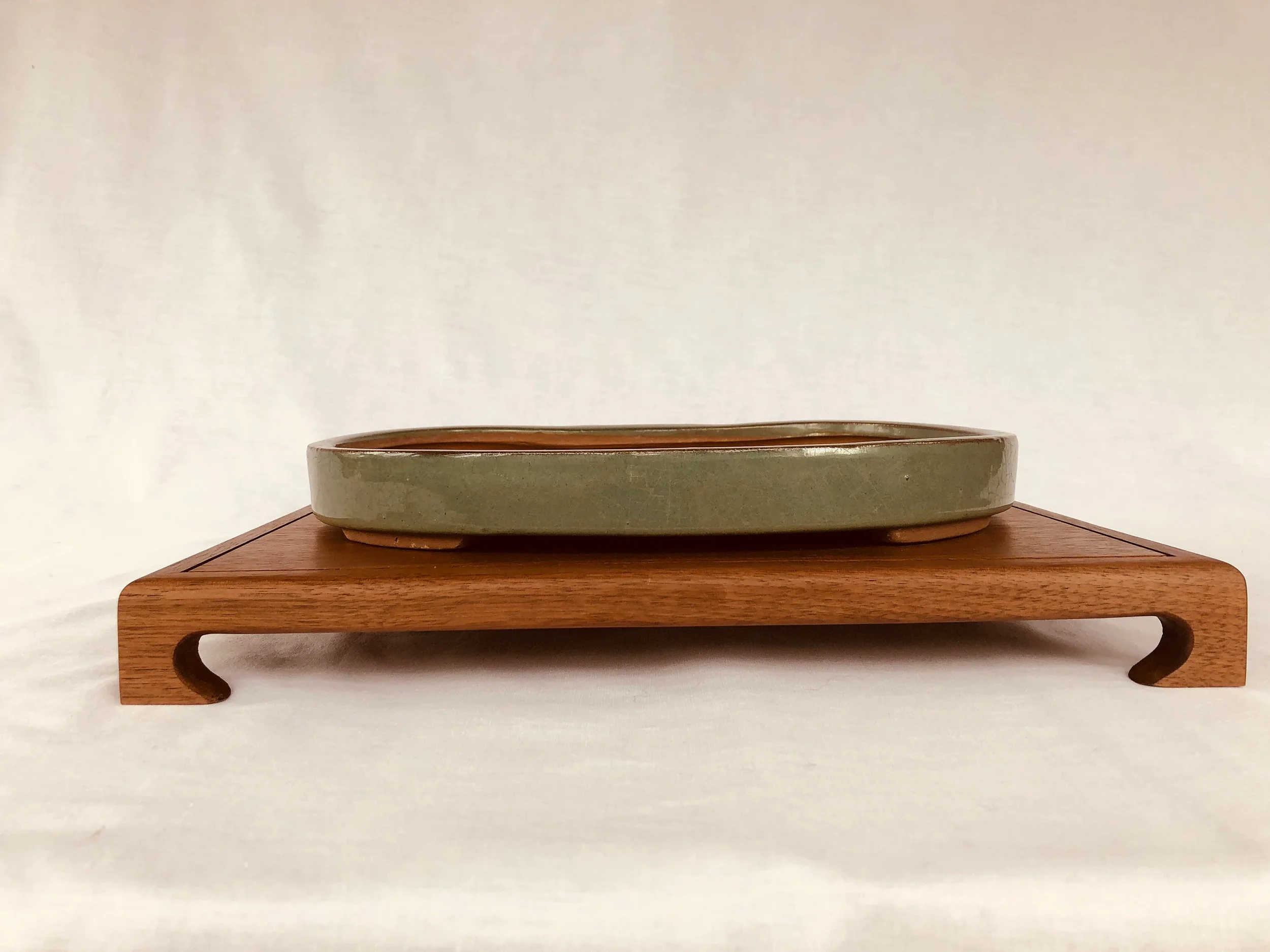 A low profile bonsai stand with curved legs