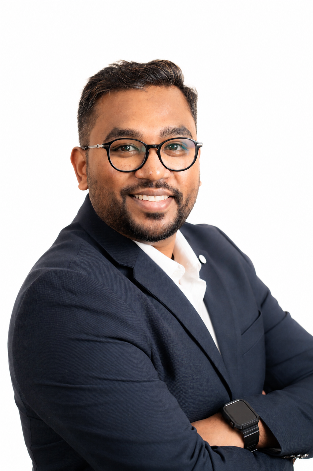 Headshot of a man with glasses wearing a navy blazer and white shirt, smiling and looking at the camera against a white background.