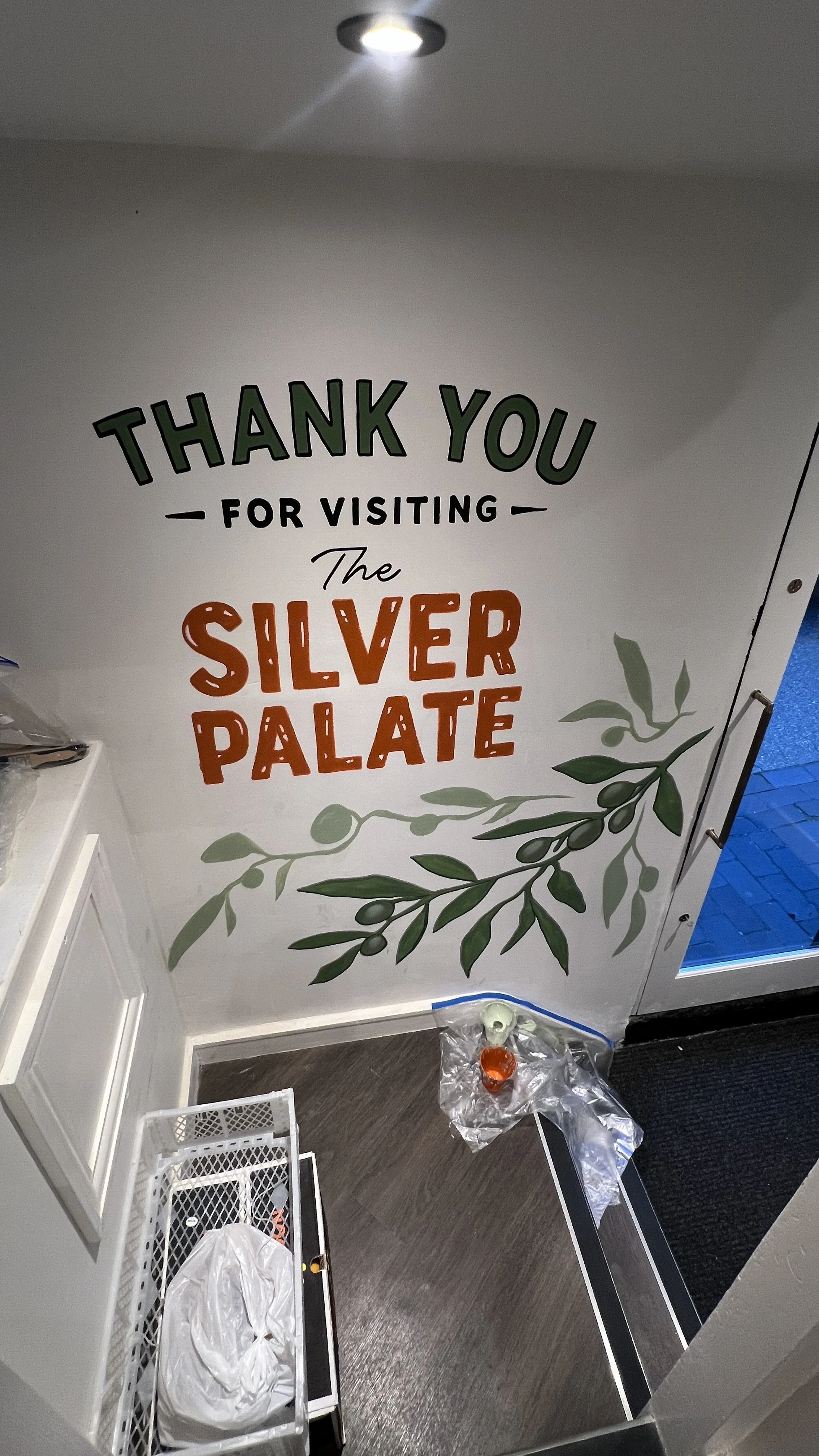 Decorative wall with a sign that says 'Thank you for visiting the Silver Palace' and includes leaf illustrations.