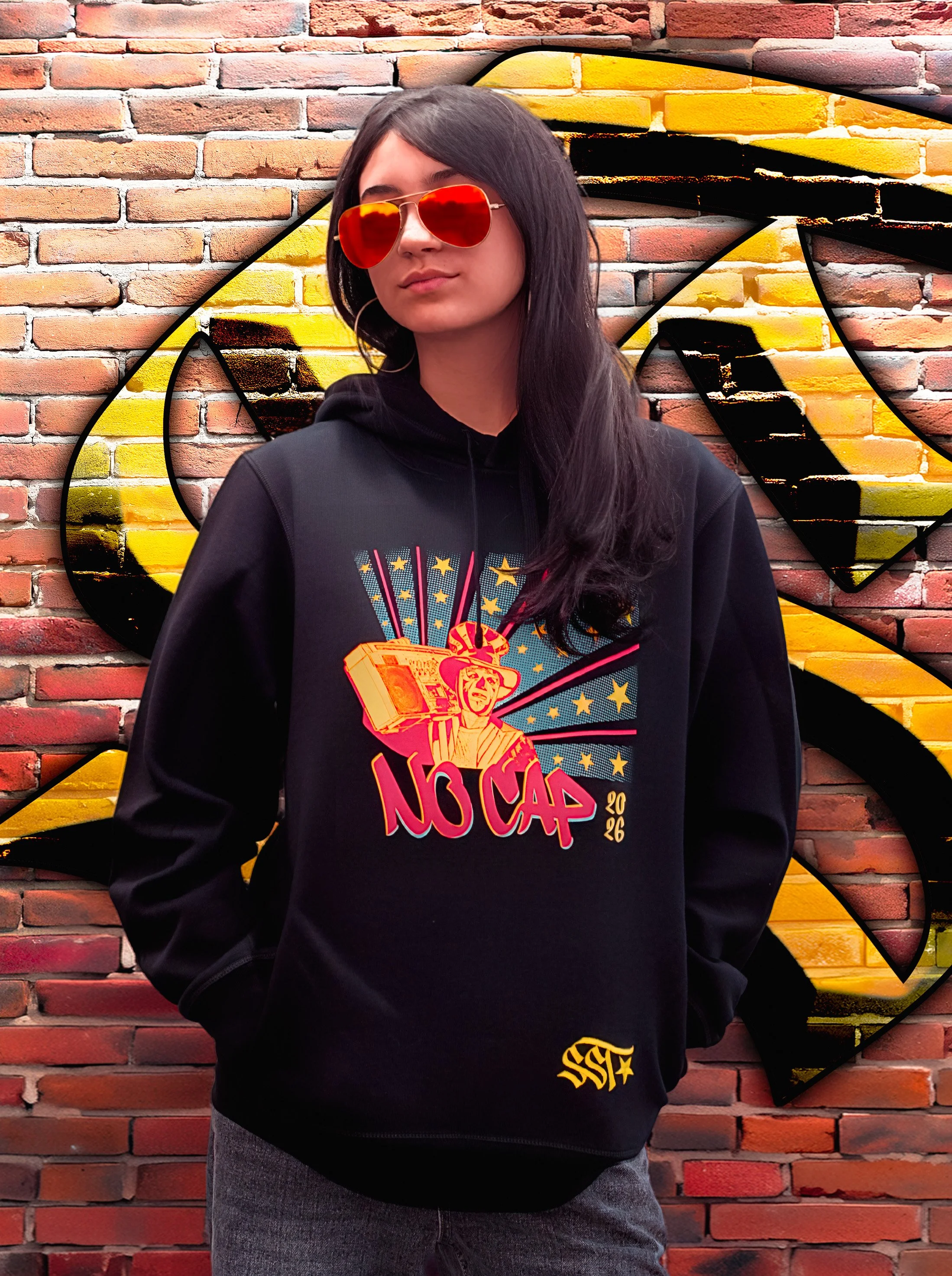 A woman wearing red sunglasses wears a limited edition black hoodie featuring the vibrant tricolor No Cap 2026 design. Behind her is the SST Street Wear logo on a brick wall.