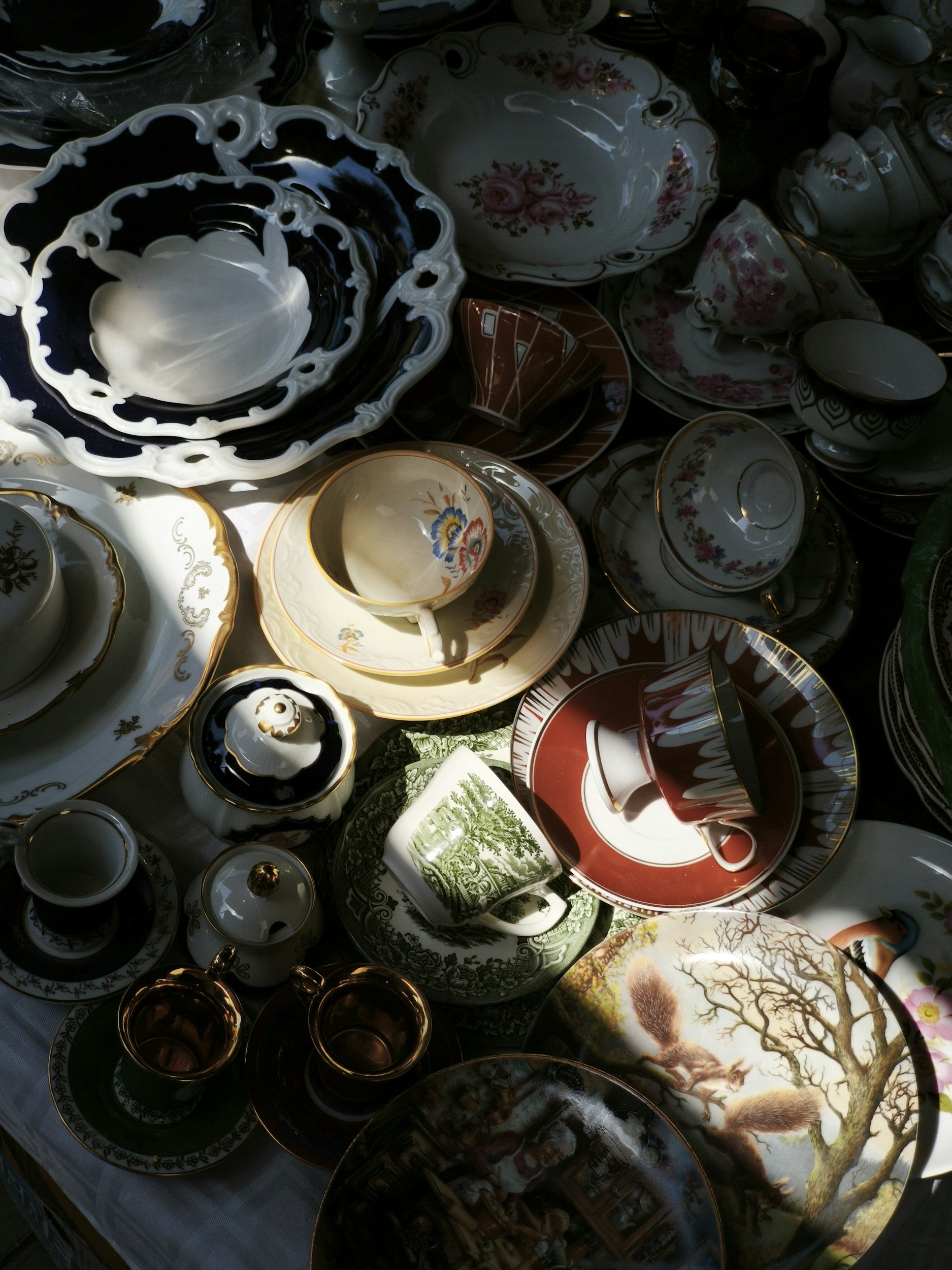 A collected mix of patterned china, teacups, and serving pieces.