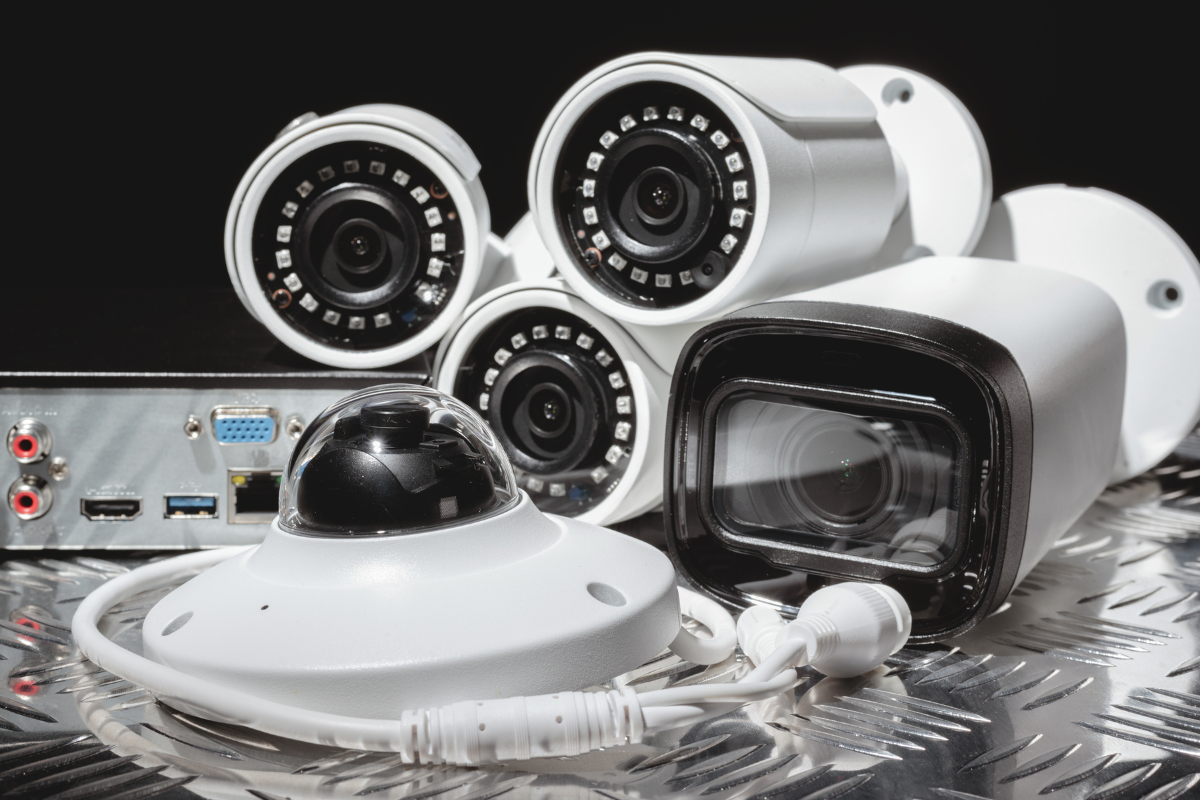 Set of security cameras and surveillance equipment on a metallic surface.