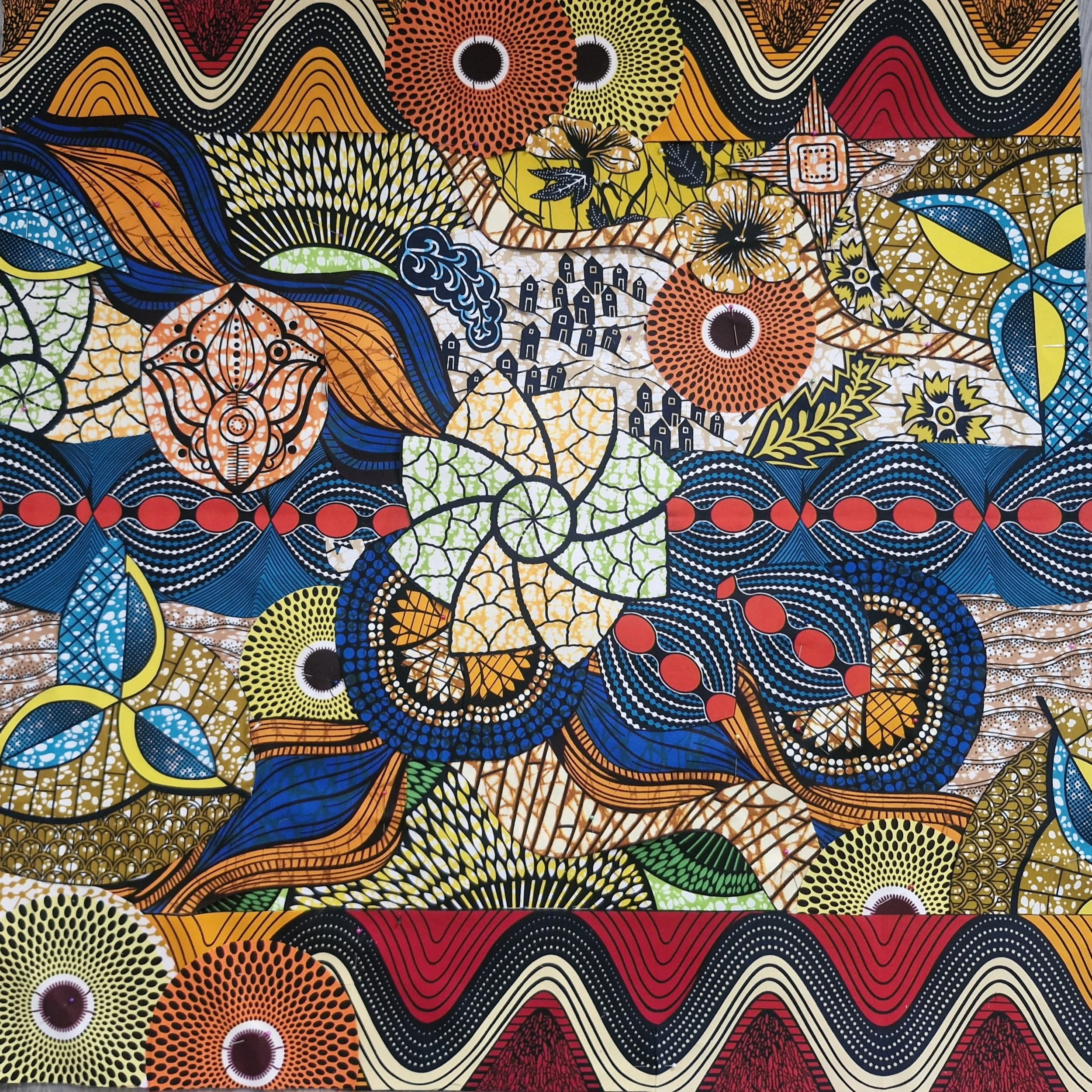 Square textile tapestry assembled from contrasting African-print fabrics, with individual patterned pieces cut and joined to form a colourful whole.