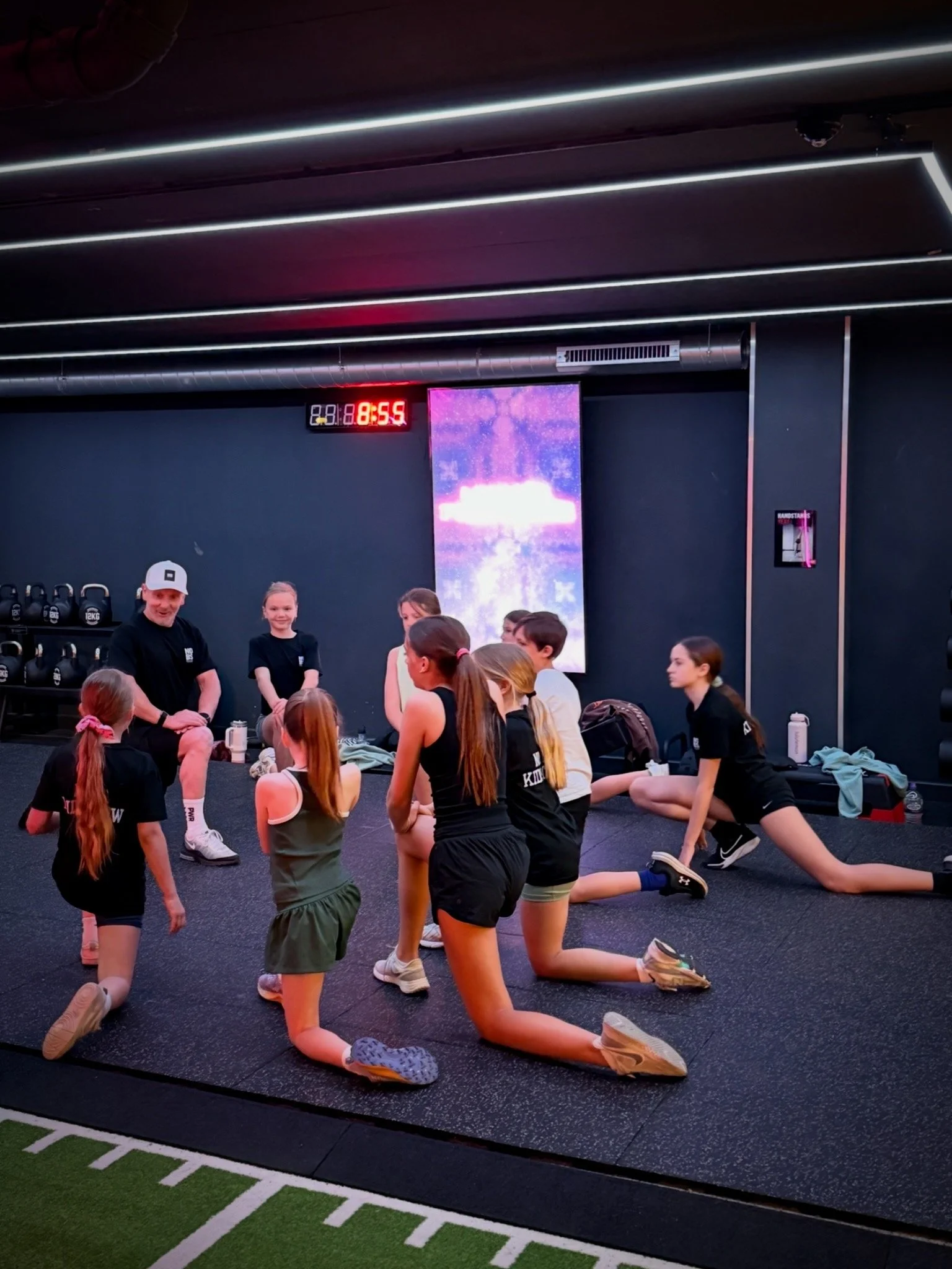 Children cooling down and stretching during a NO BS Kids Crew functional fitness session in Farnham.