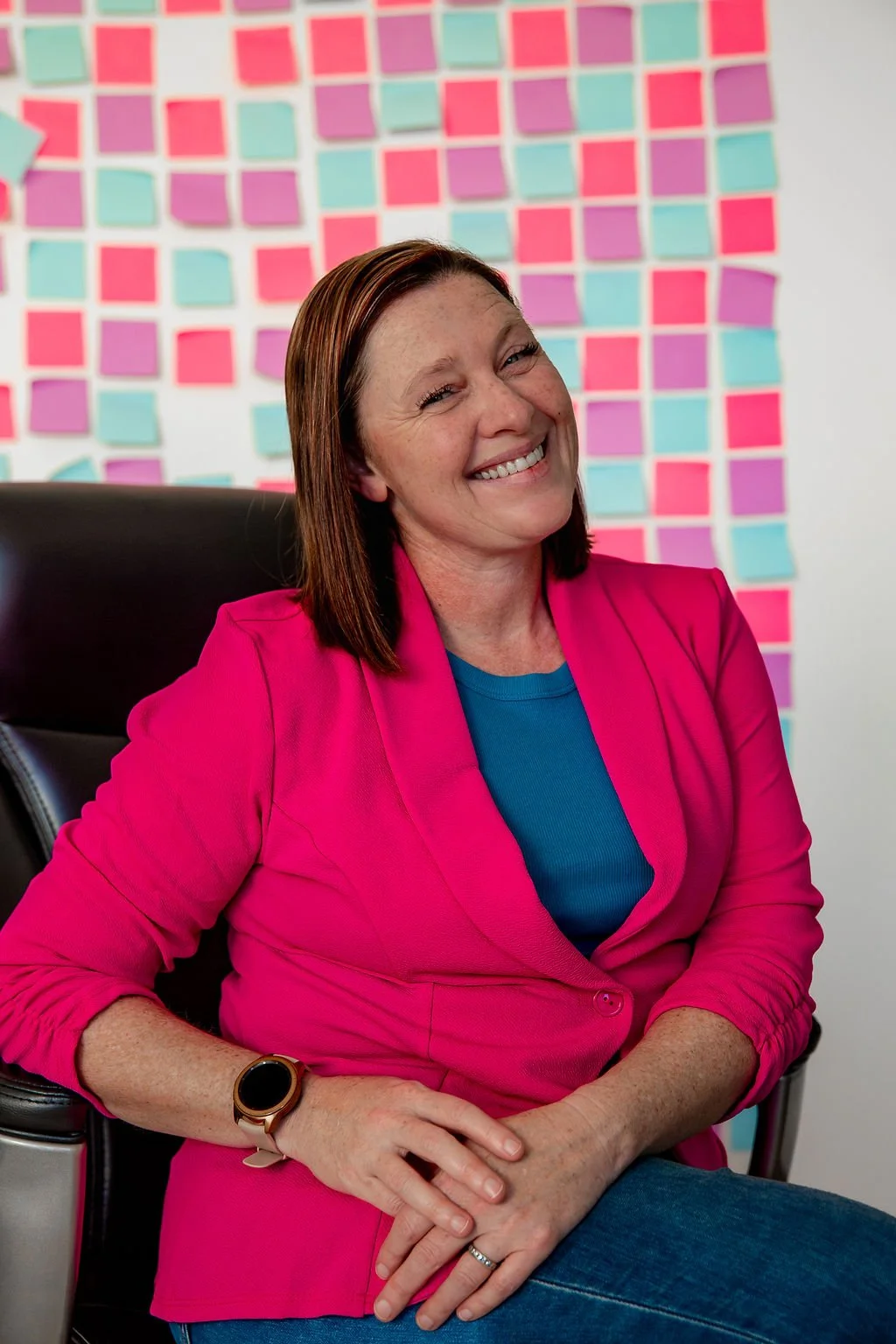 Liz Chapman, podcast producer, sitting at her desk smiling at the camera