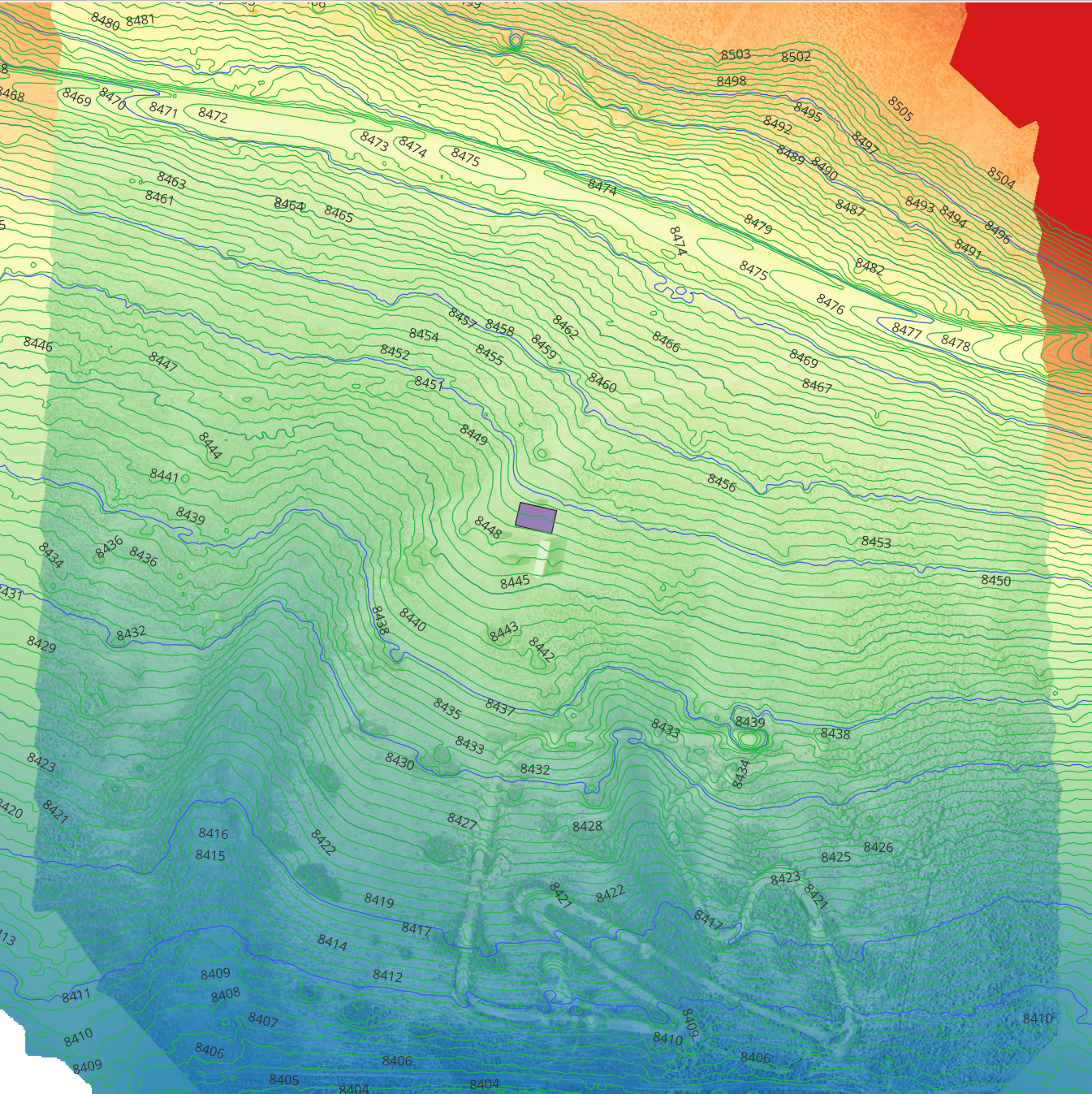 Topographic map showing elevation contours, streams, and a small building marked in purple, with areas of high elevation in red and lower elevations in green and blue.