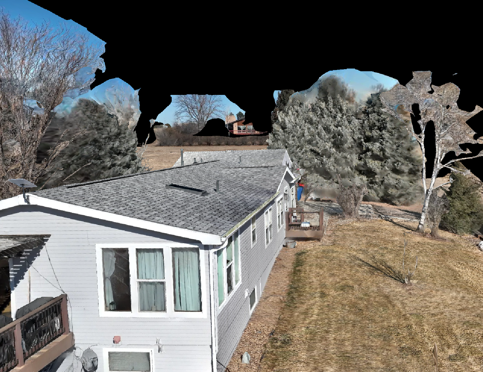 A house with a gray roof and white siding, surrounded by trees and a yard, with some trees without leaves and others with snow-covered branches, under a partly cloudy sky.