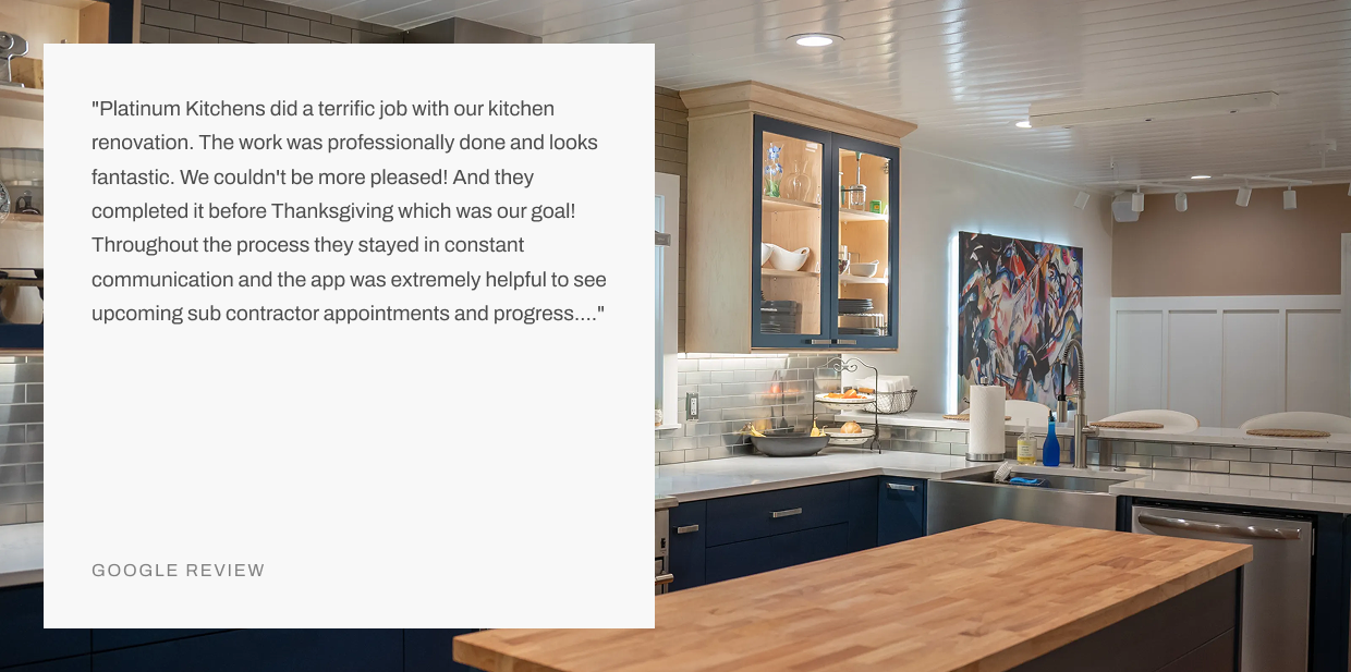 Renovated kitchen with navy blue cabinets, white subway tile backsplash, wood island countertop, glass-front cabinets, and Google review overlay