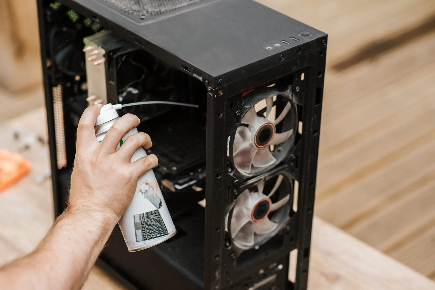 Cleaning dust from inside a desktop computer with compressed air.