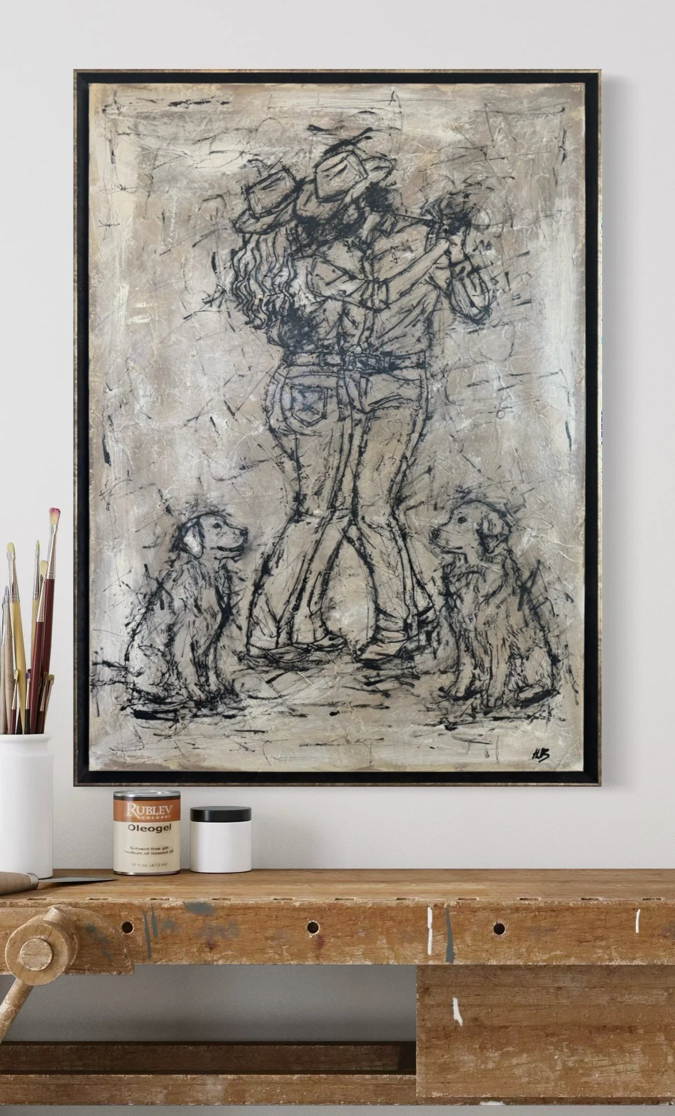 A black and white abstract drawing of a woman holding two dogs, with a textured background, displayed on a wall. Art supplies are visible nearby.
