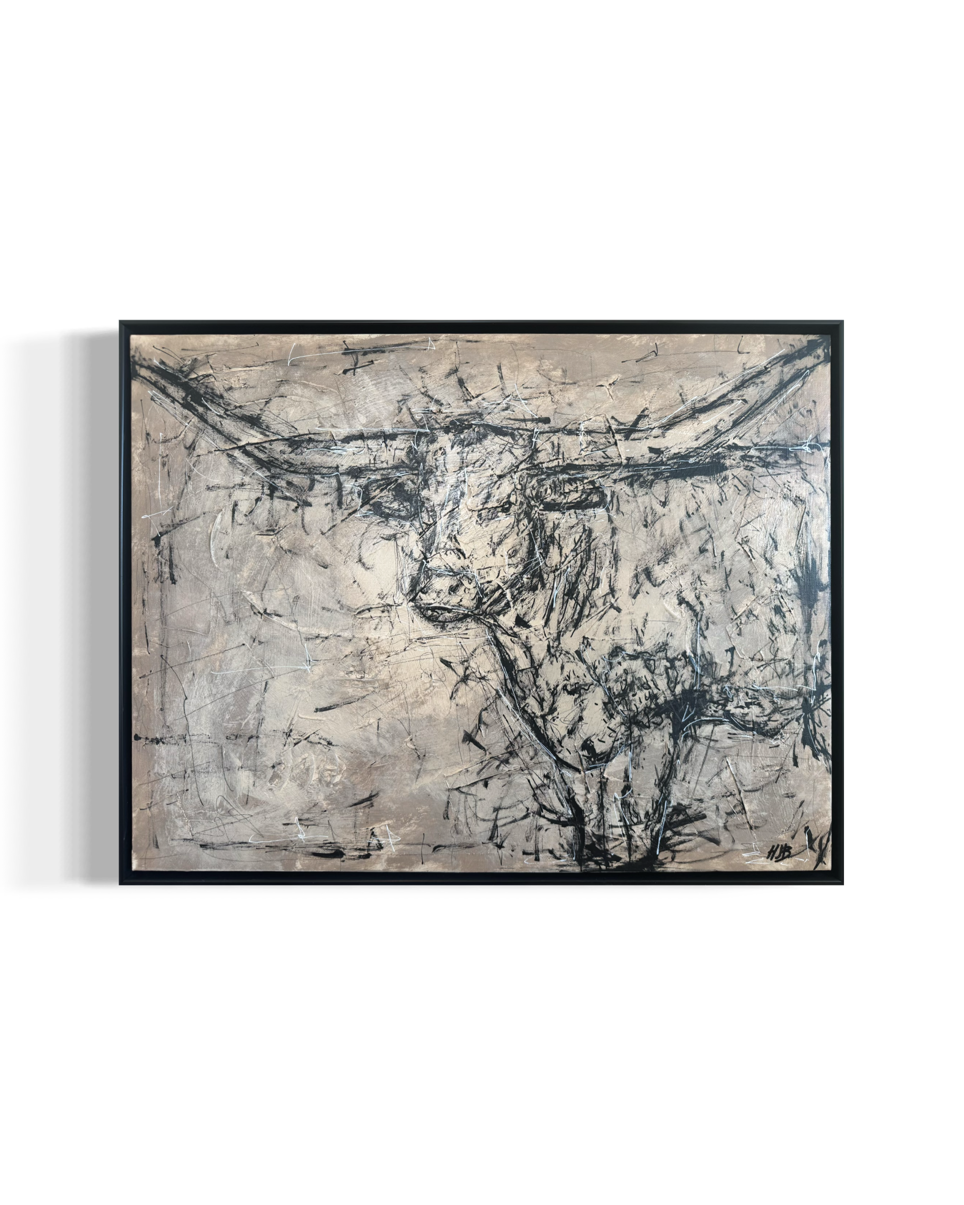 Abstract black and white painting with chaotic lines and splashes, framed on a white wall.
