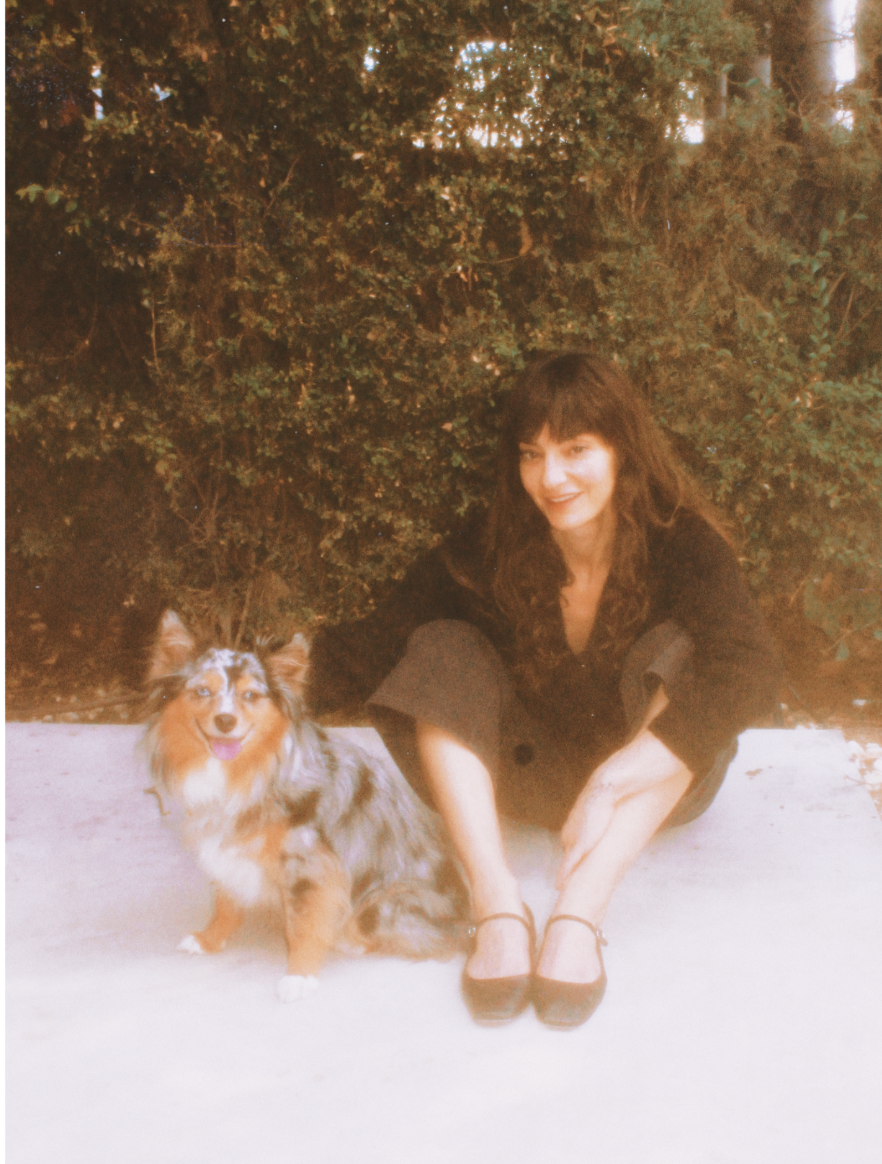 Rachel Rose Katz sitting outdoors with her dog, Babooshka