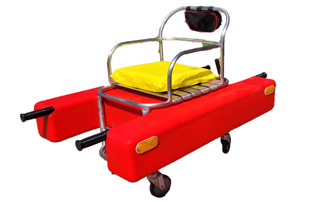 A red rescue device  with a yellow cushion and a small black bag attached to the metal frame, equipped with wheels.